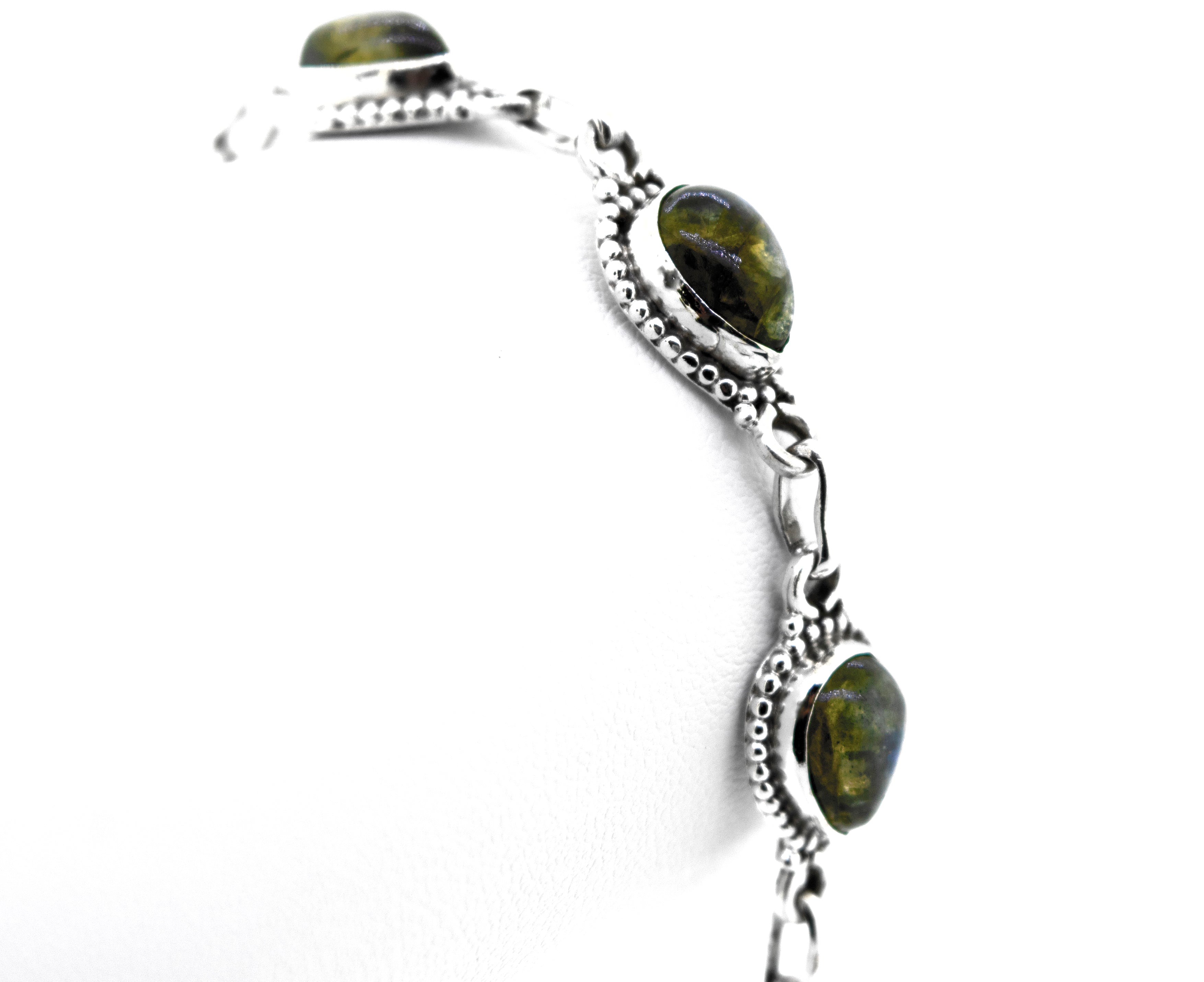 A stunning .925 silver Teardrop Shape Stone Bracelet With Ball Border featuring greenish-black Labradorite oval stones set in intricate metalwork with alternating links.