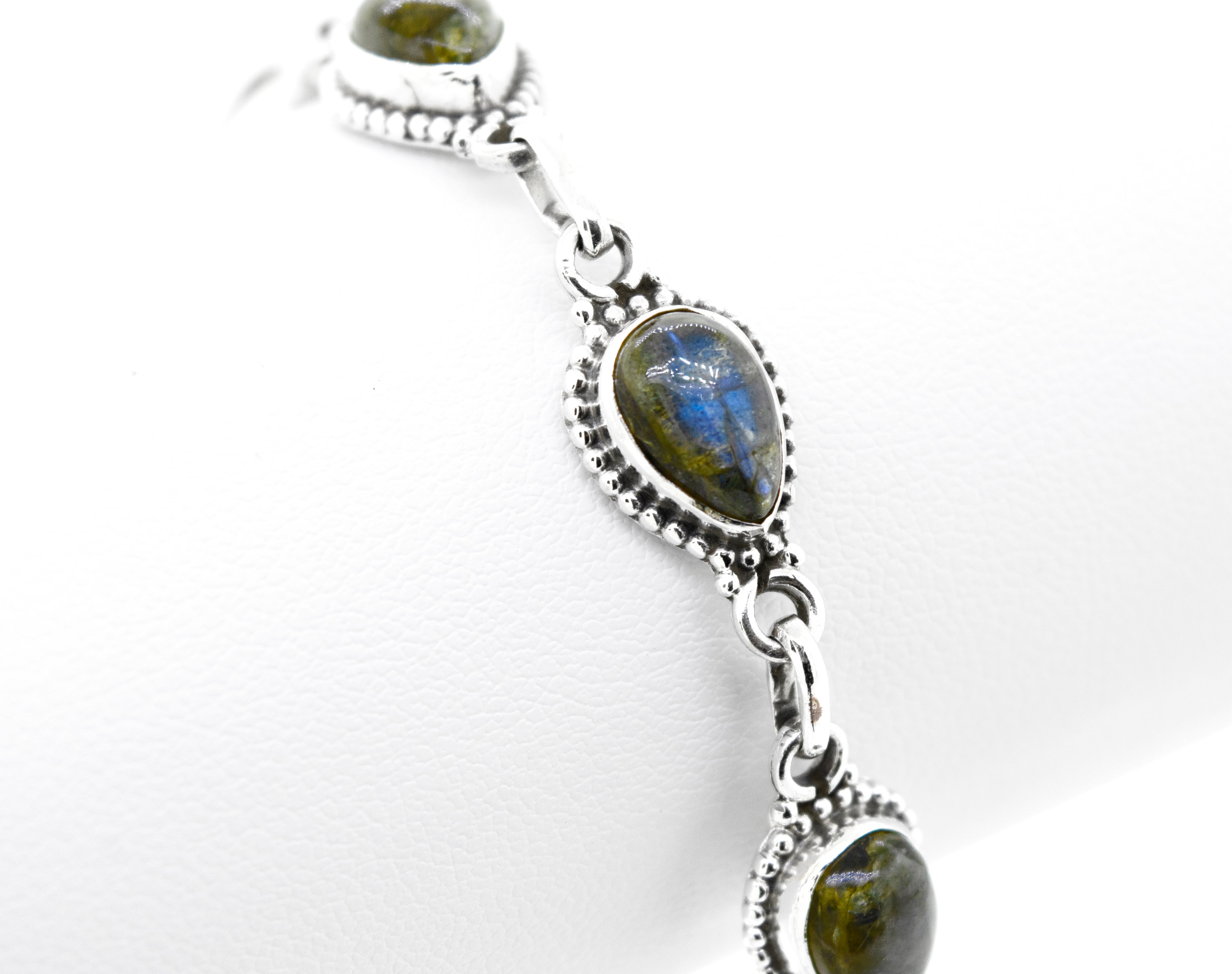 A stunning Teardrop Shape Stone Bracelet With Ball Border featuring multiple gemstones set in teardrop-shaped bezels, displayed on a white background.