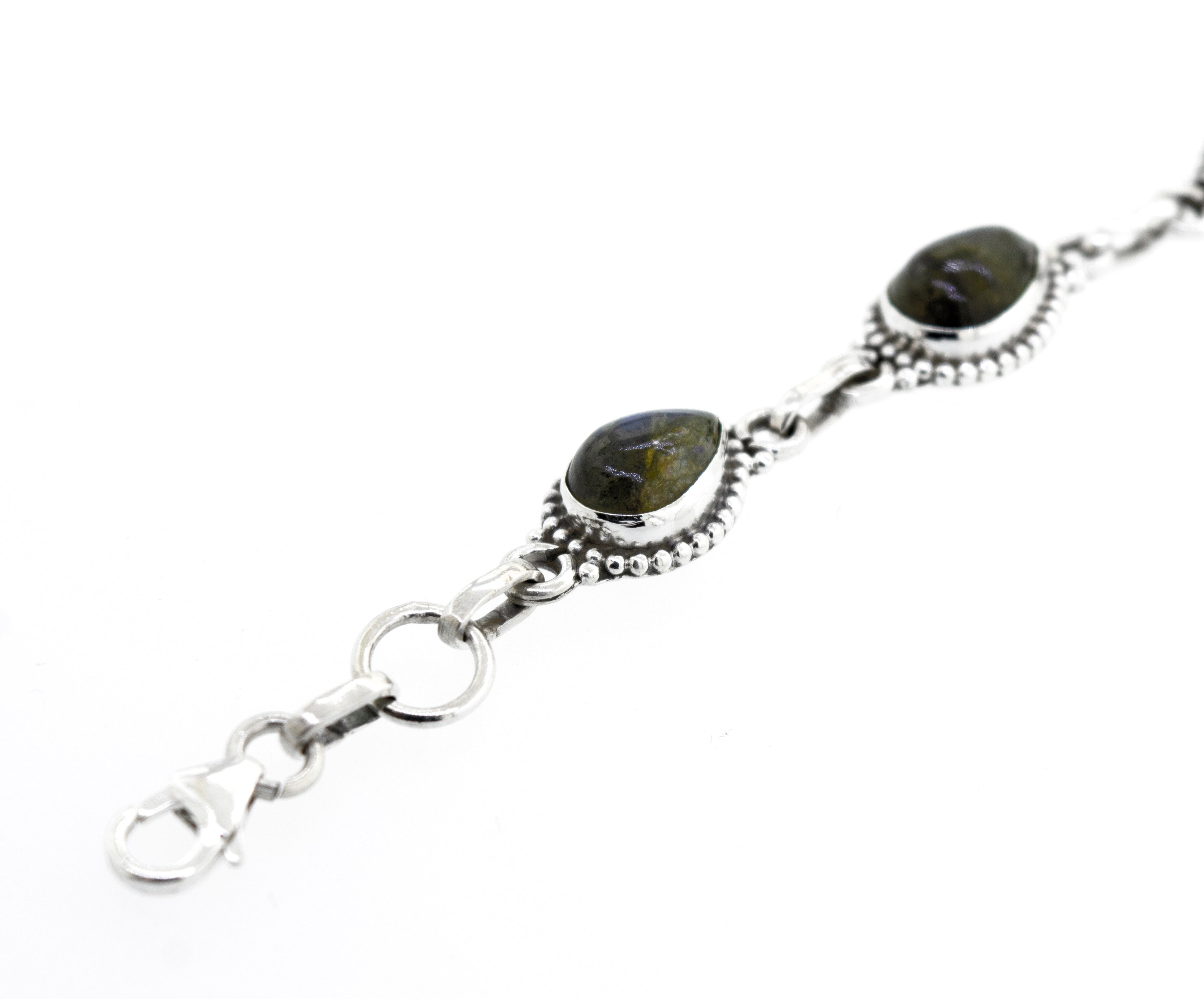 Close-up view of a Teardrop Shape Stone Bracelet With Ball Border adorned with two dark-colored Labradorite stones set in decorative metalwork, featuring a clasp at one end. The bracelet is isolated against a white background.