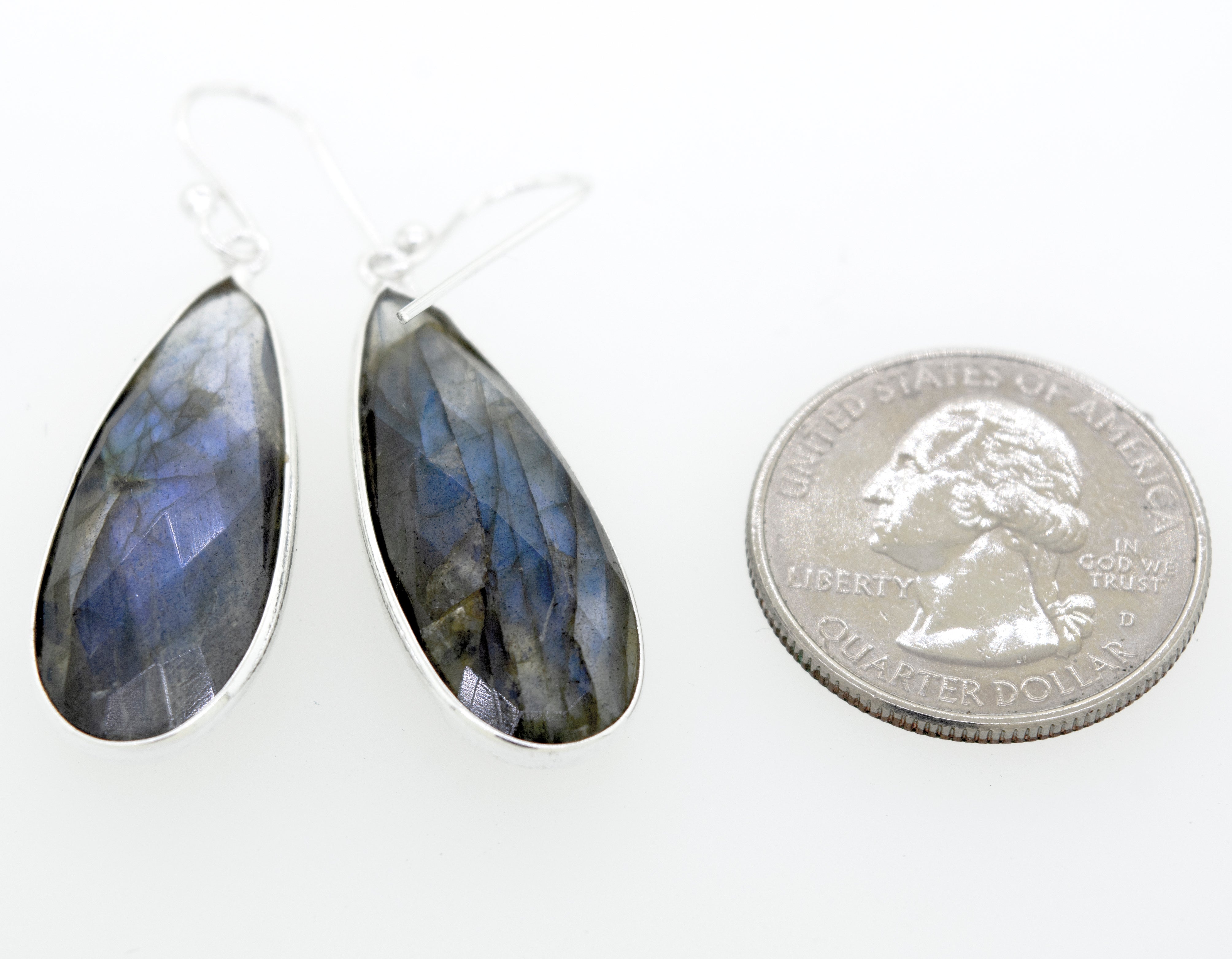 Super Silver's Elegant Facet Cut Teardrop Shape Labradorite Earrings sparkling beside a quarter.