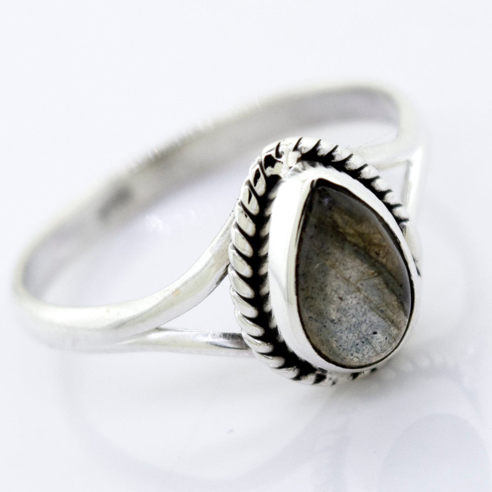 Vibrant teardrop shape stone ring with an oval gray gemstone set in a detailed band, displayed against a white background.