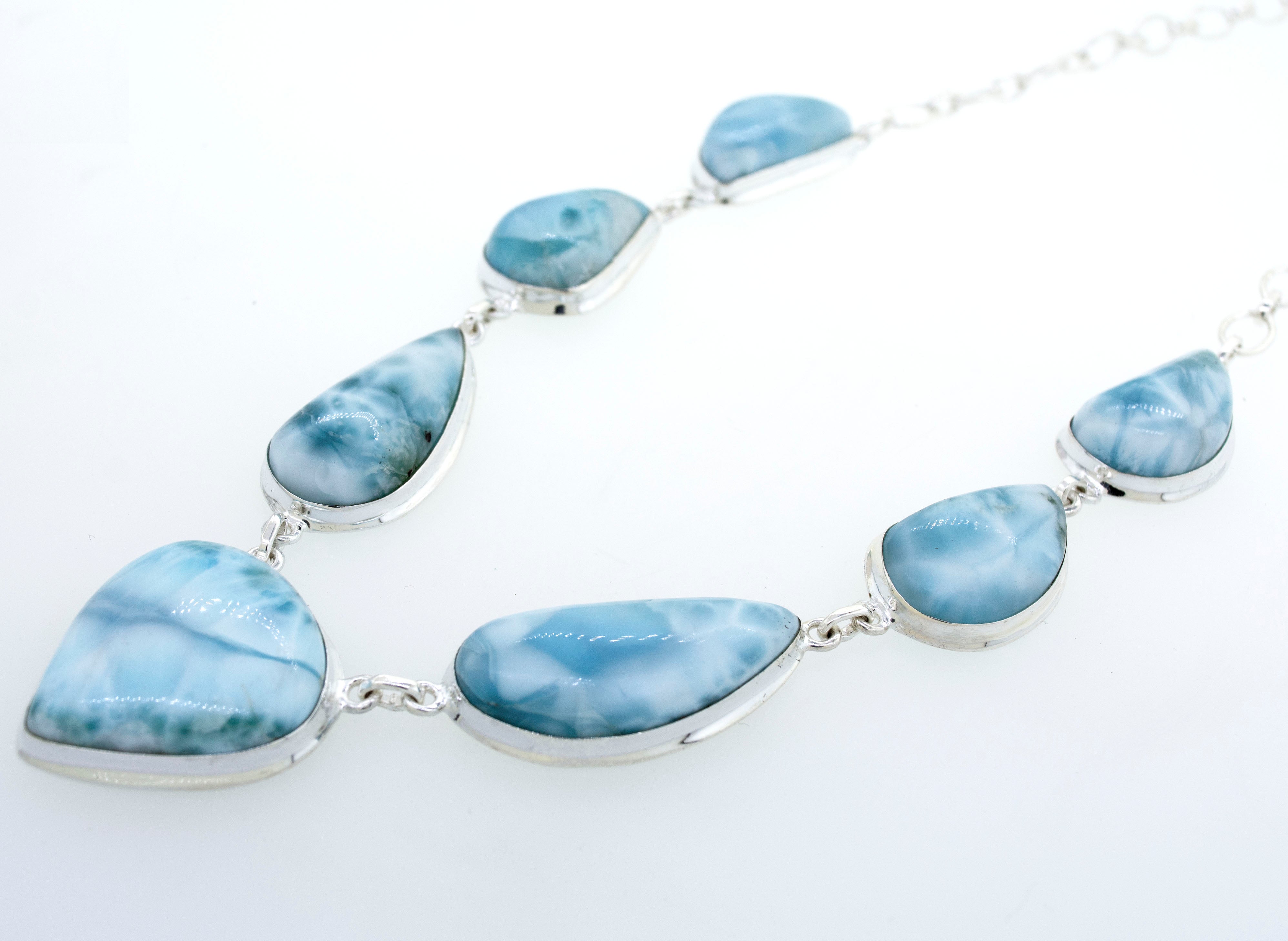 A beautiful Super Silver Larimar Necklace With Teardrop Shape Stones on a white surface.