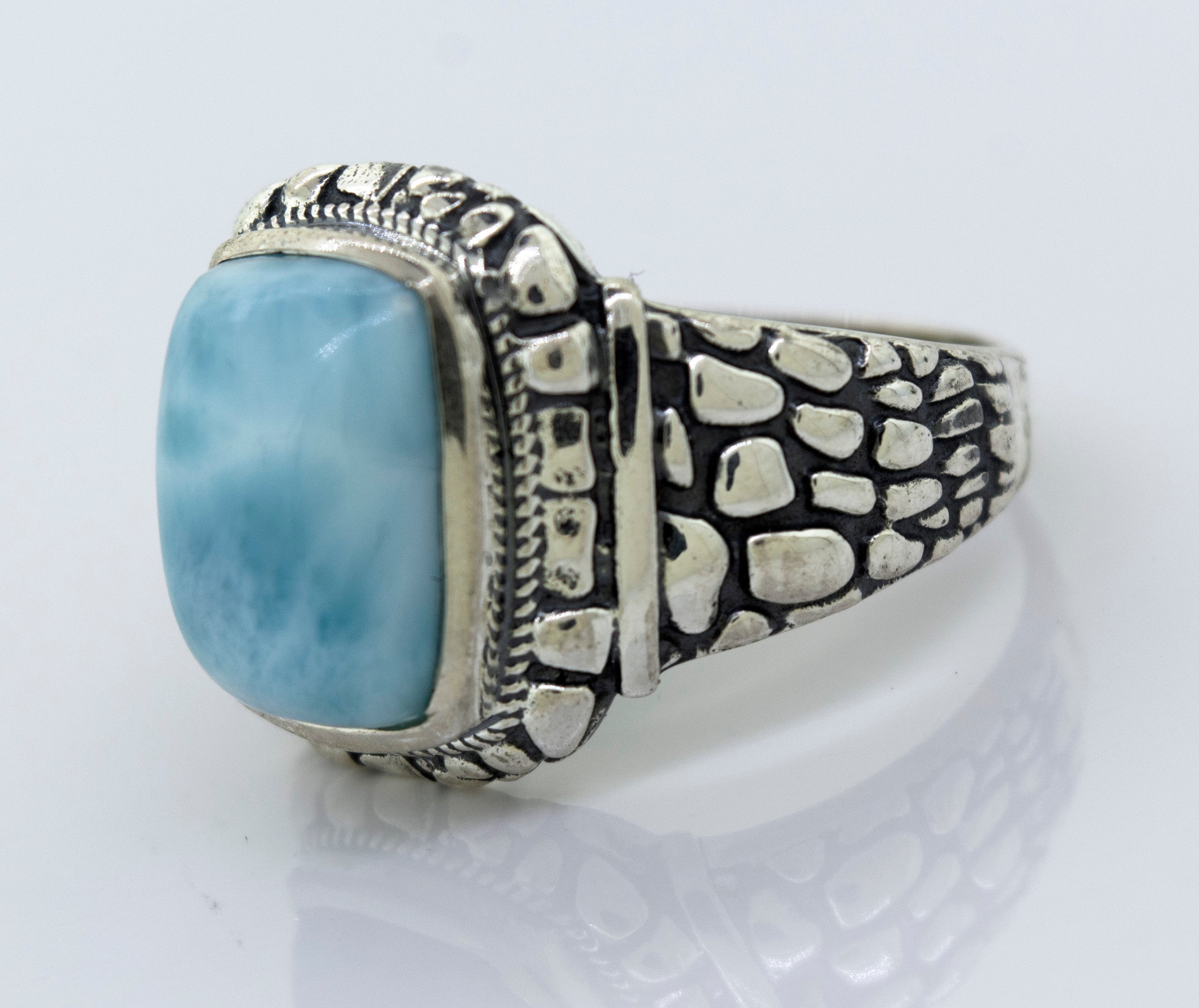 A minimalist Larimar Signet Ring With Dragon Scale Pattern with a large blue stone.