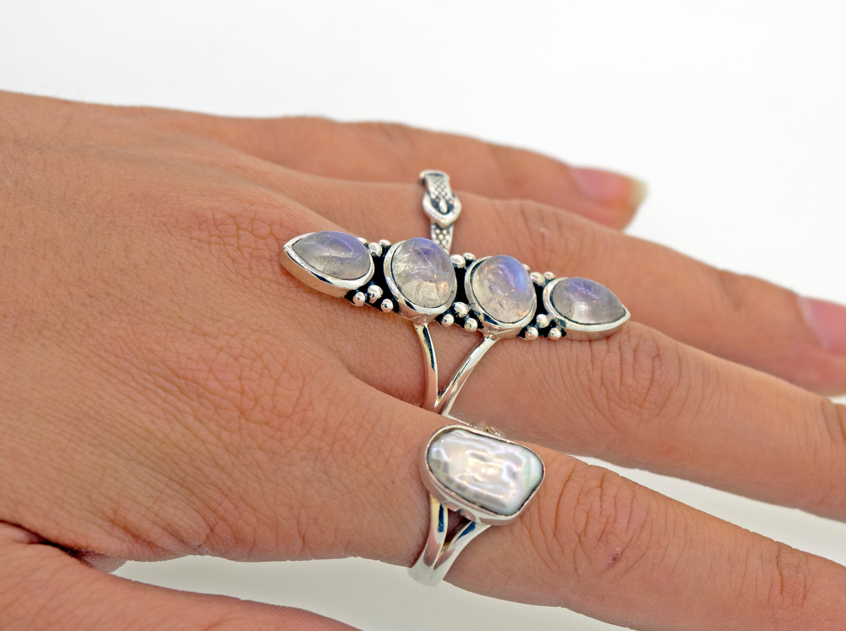 A woman's hand showcasing a Super Silver Elongated Moonstone Ring adorned with three mesmerizing moonstones, available for purchase on our online store.