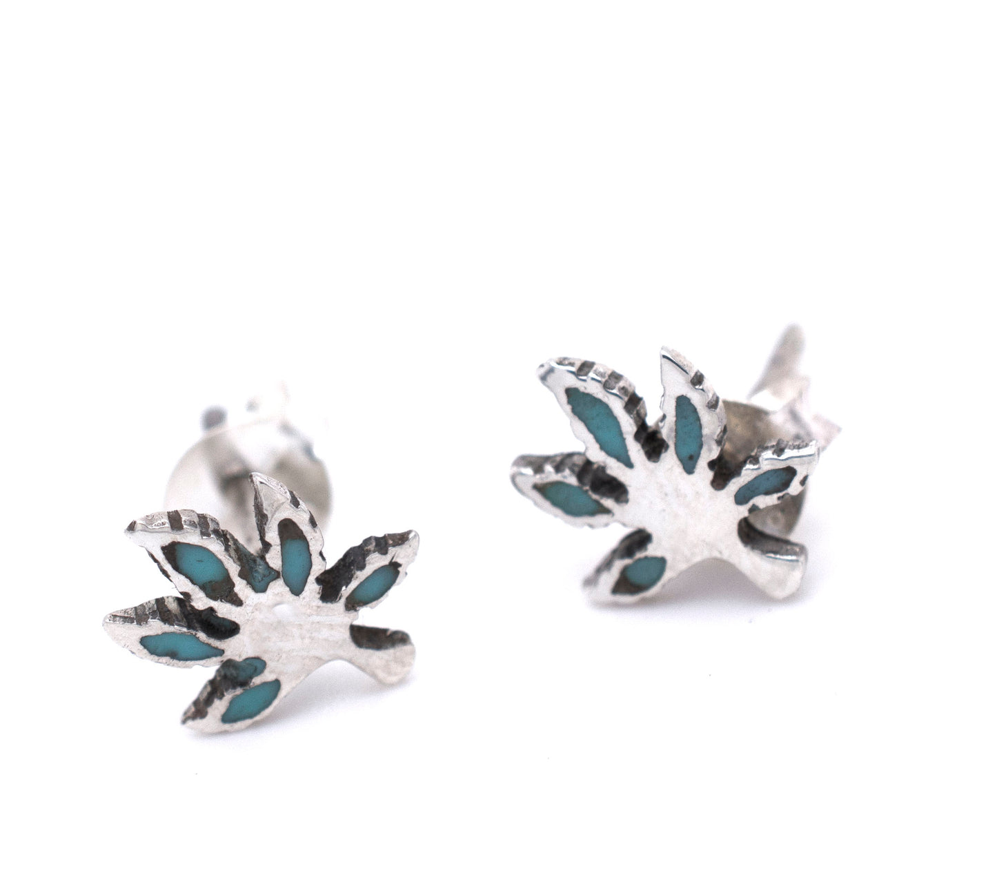 A pair of Super Silver turquoise leaf stud earrings featuring a subtle marijuana leaf design.