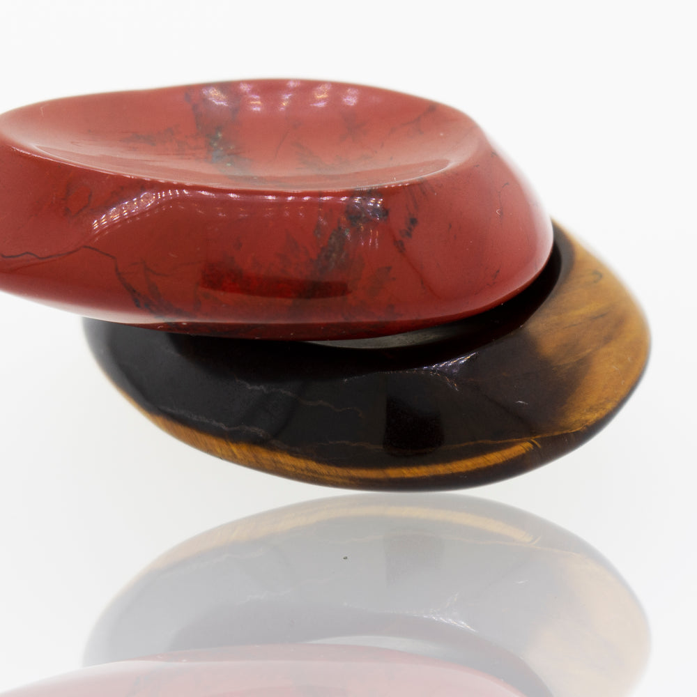 A red, black and yellow worry stone ring with a crystal stone.