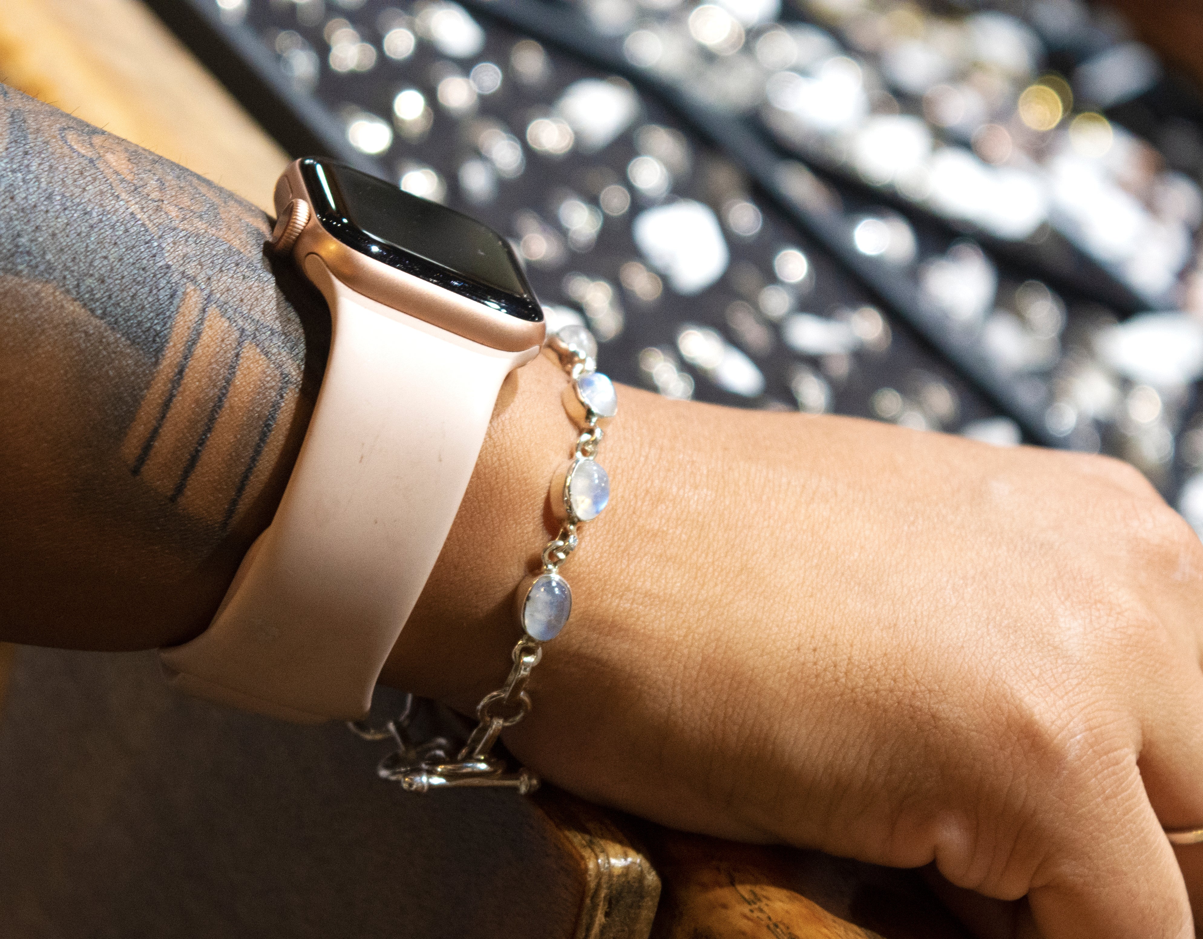 A woman wearing a Super Silver Vibrant Oval Moonstone Bracelet on her wrist.