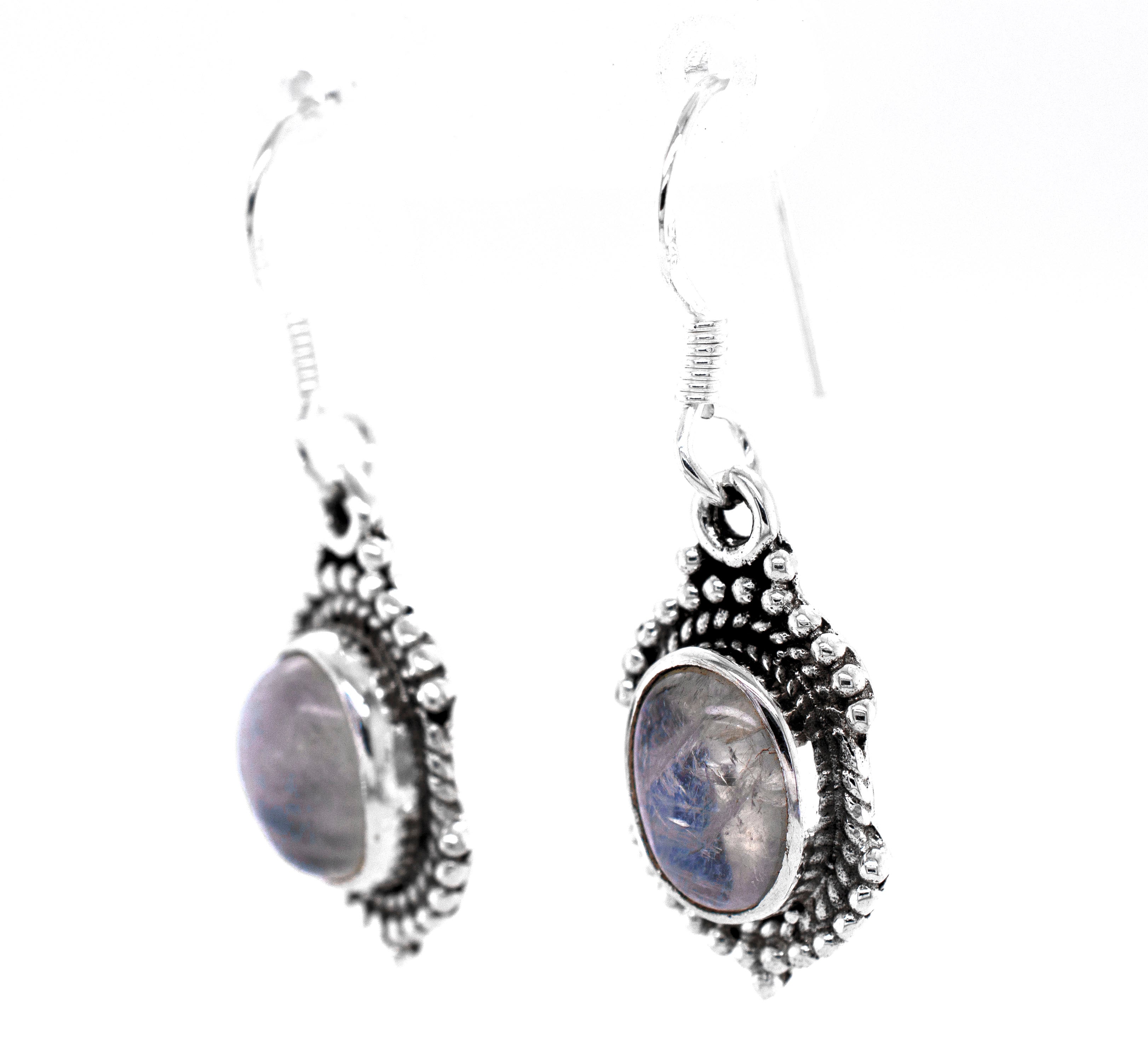 A pair of Super Silver Luminous Oval Moonstone Earrings with a blue stone.