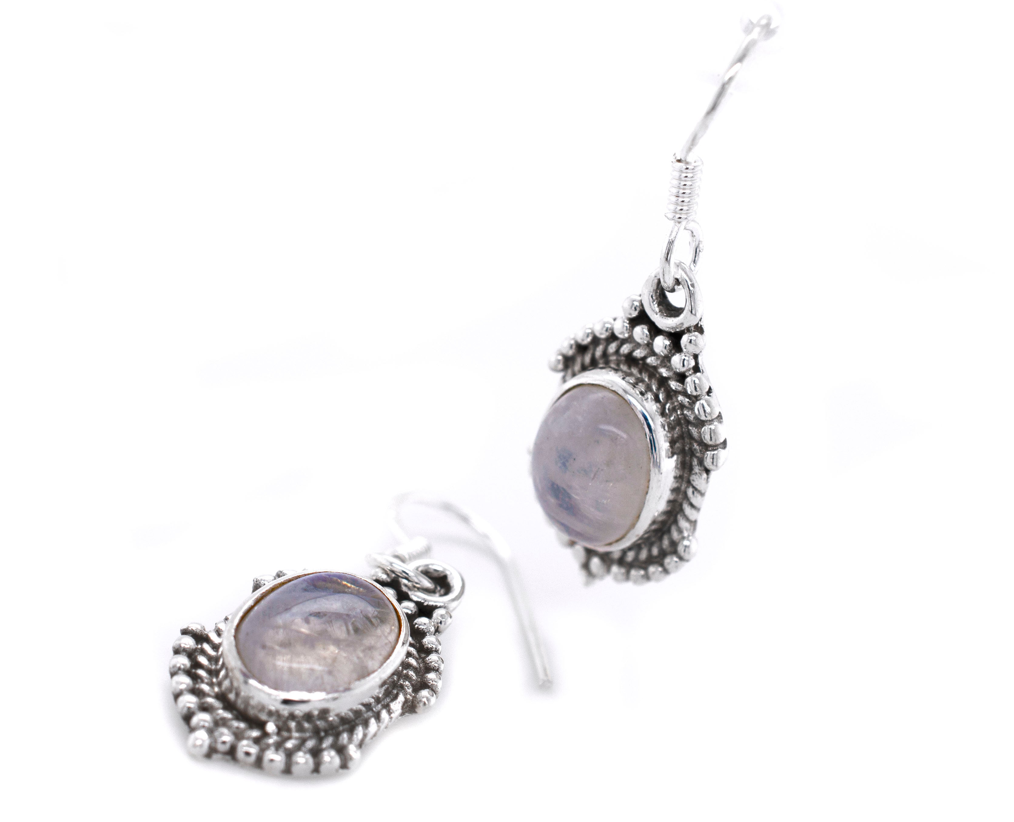 A pair of Super Silver Luminous Oval Moonstone Earrings adorned with a delicate moonstone stone.