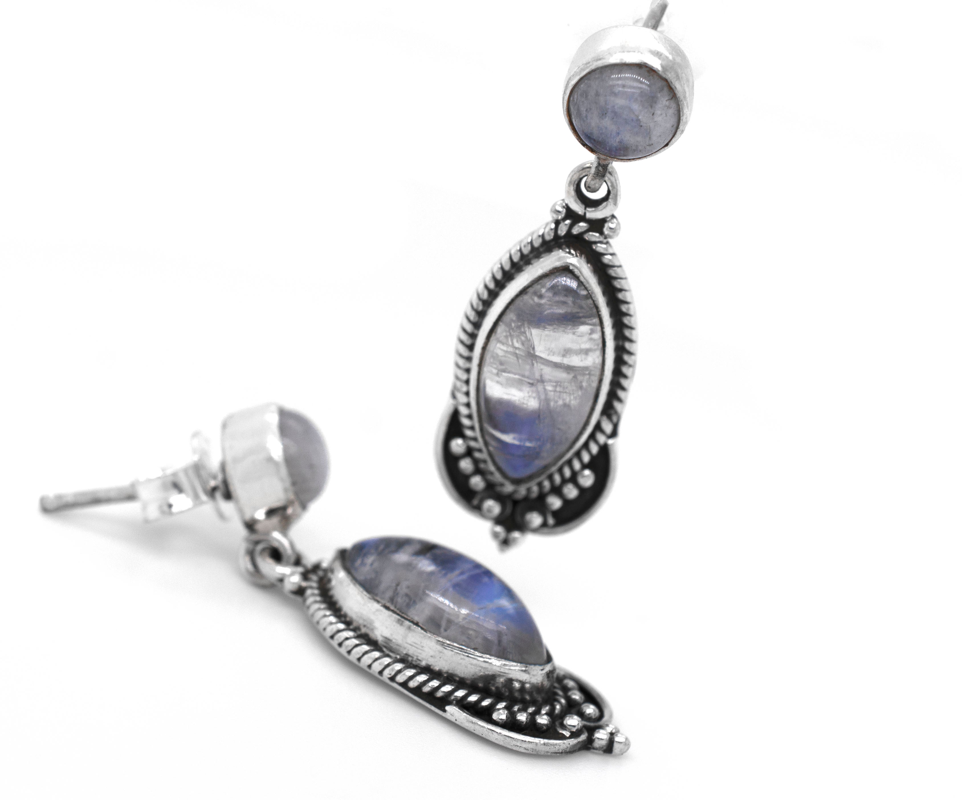 A pair of Super Silver's Captivating Moonstone Earrings with a blue moonstone in an oxidized rope setting.