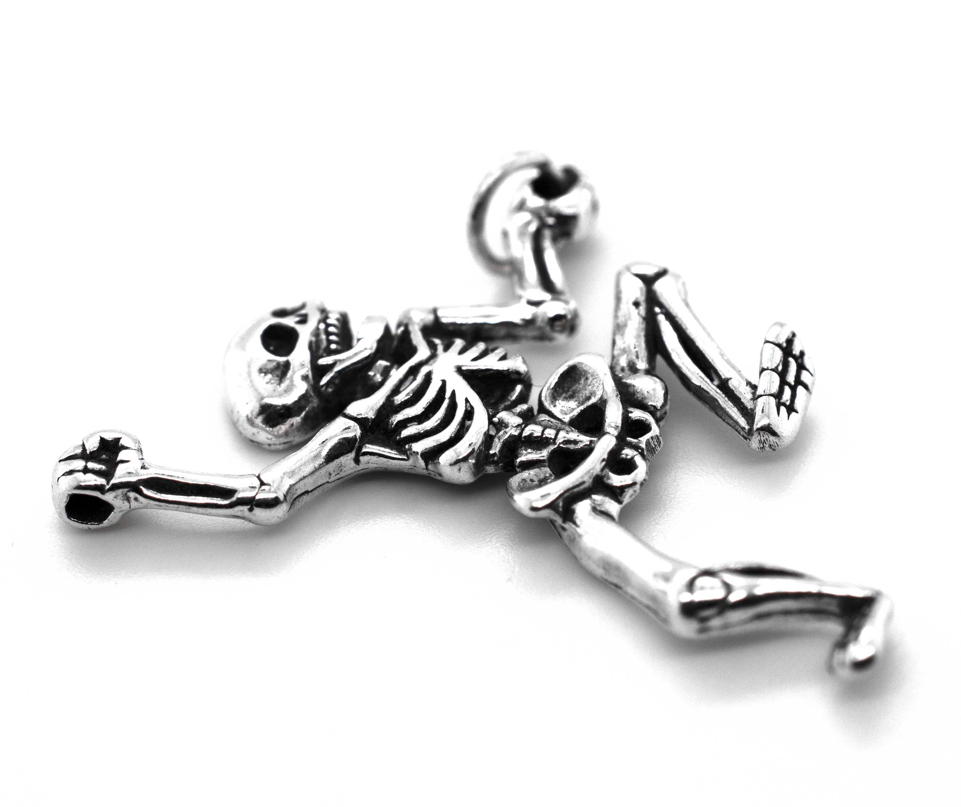 The Dancing Skeleton Pendant, crafted in sterling silver with detailed bones, is displayed on a white background—perfect as a Halloween necklace.