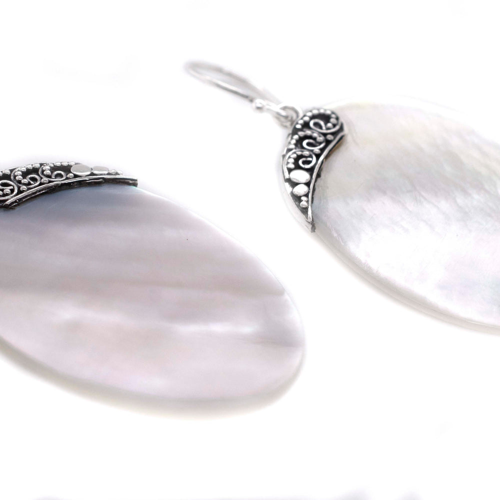 A pair of Super Silver Simple Mother Of Pearl Statement Earrings on a white background.