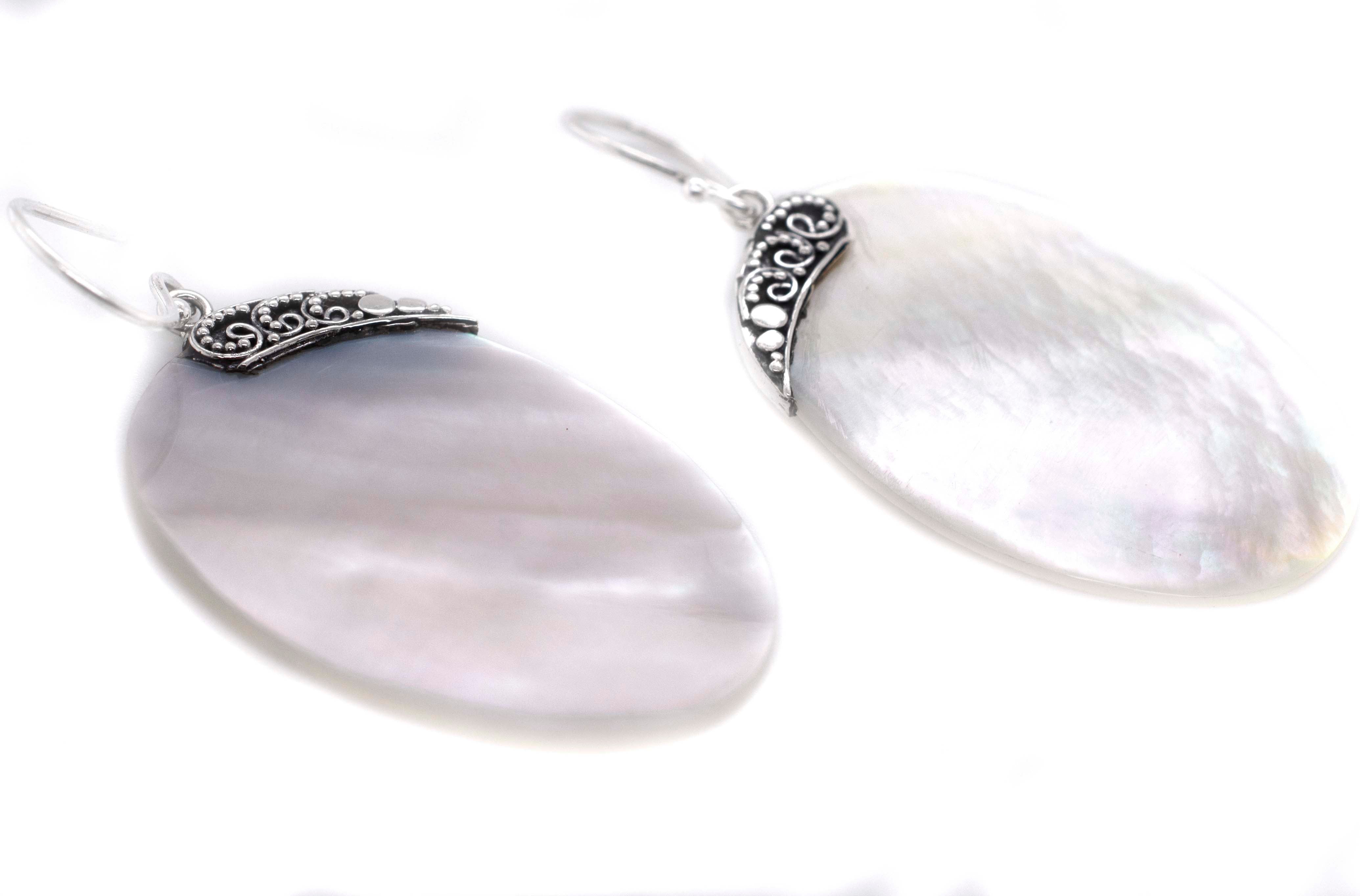 A pair of Super Silver Simple Mother Of Pearl Statement Earrings on a white background.