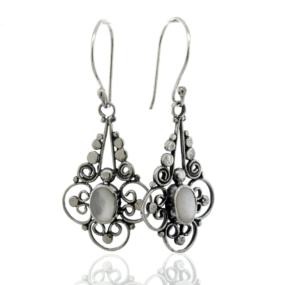 A pair of Super Silver Oval Mother Of Pearl Dangle Earrings With A Flower Design.