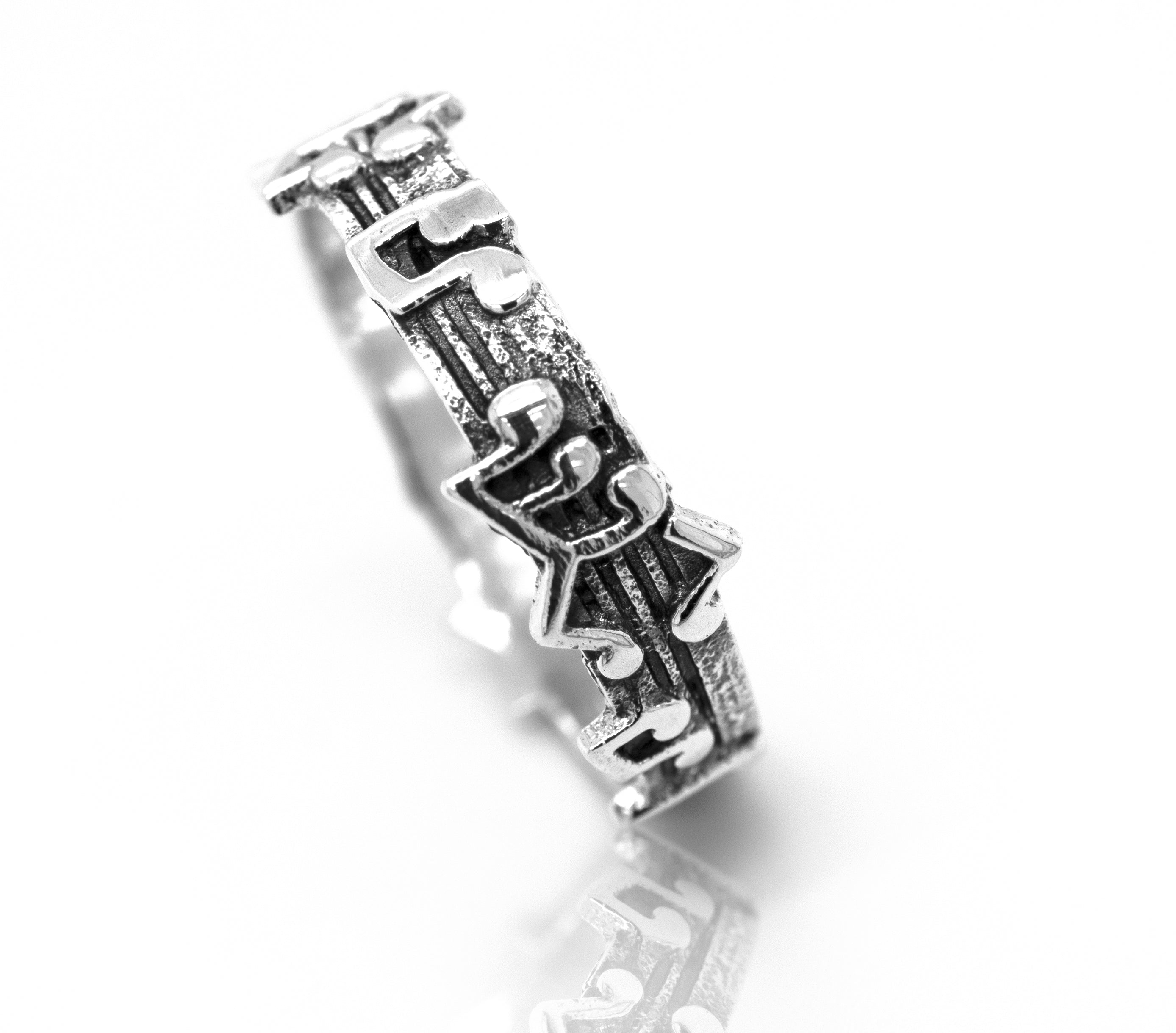 An oxidized Super Silver band with a puzzle design on it.