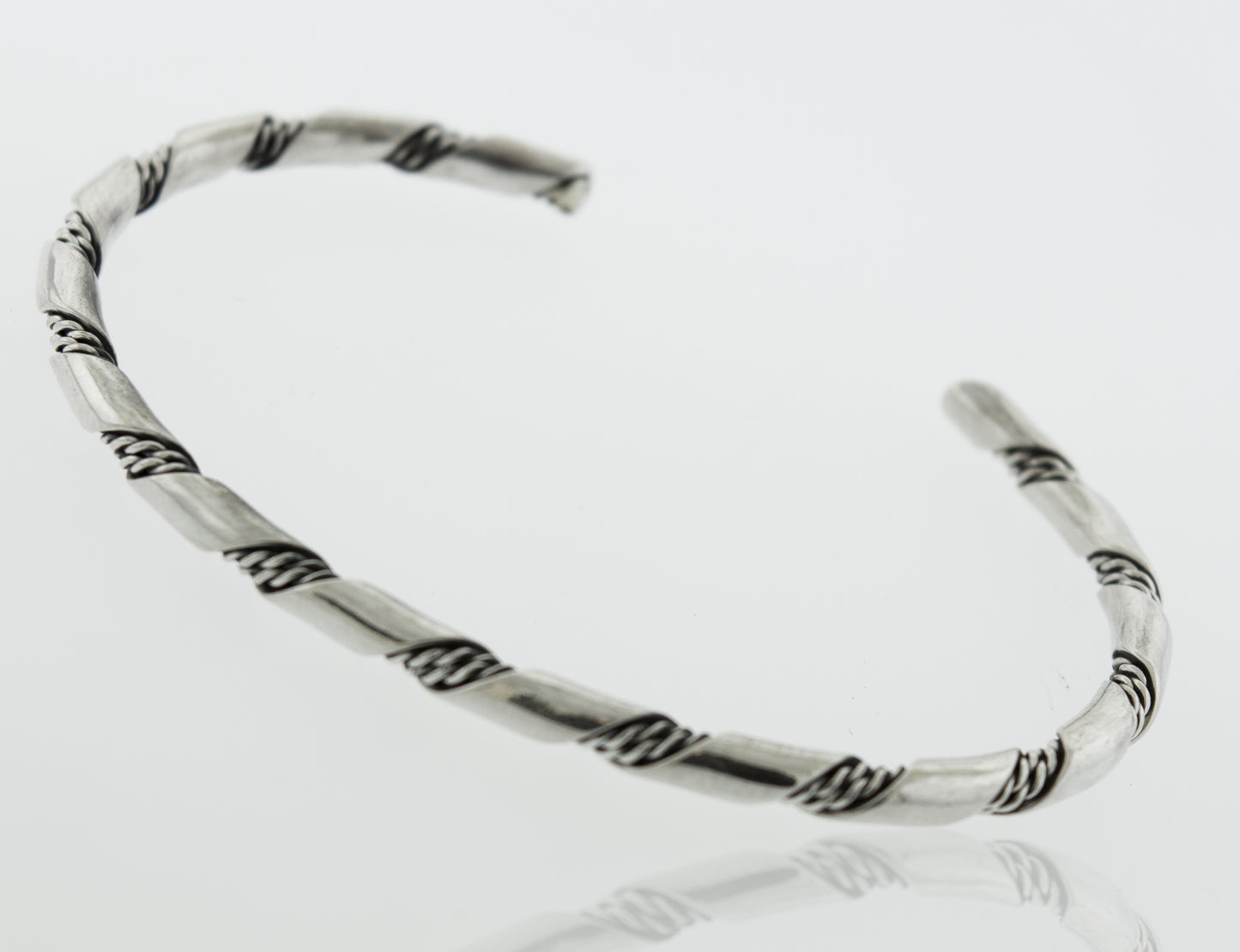 
                  
                    A Native American Handmade Thin Silver Twist Cuff from Super Silver, with a braided design, perfect for stacking or adding a stylish touch to any outing.
                  
                