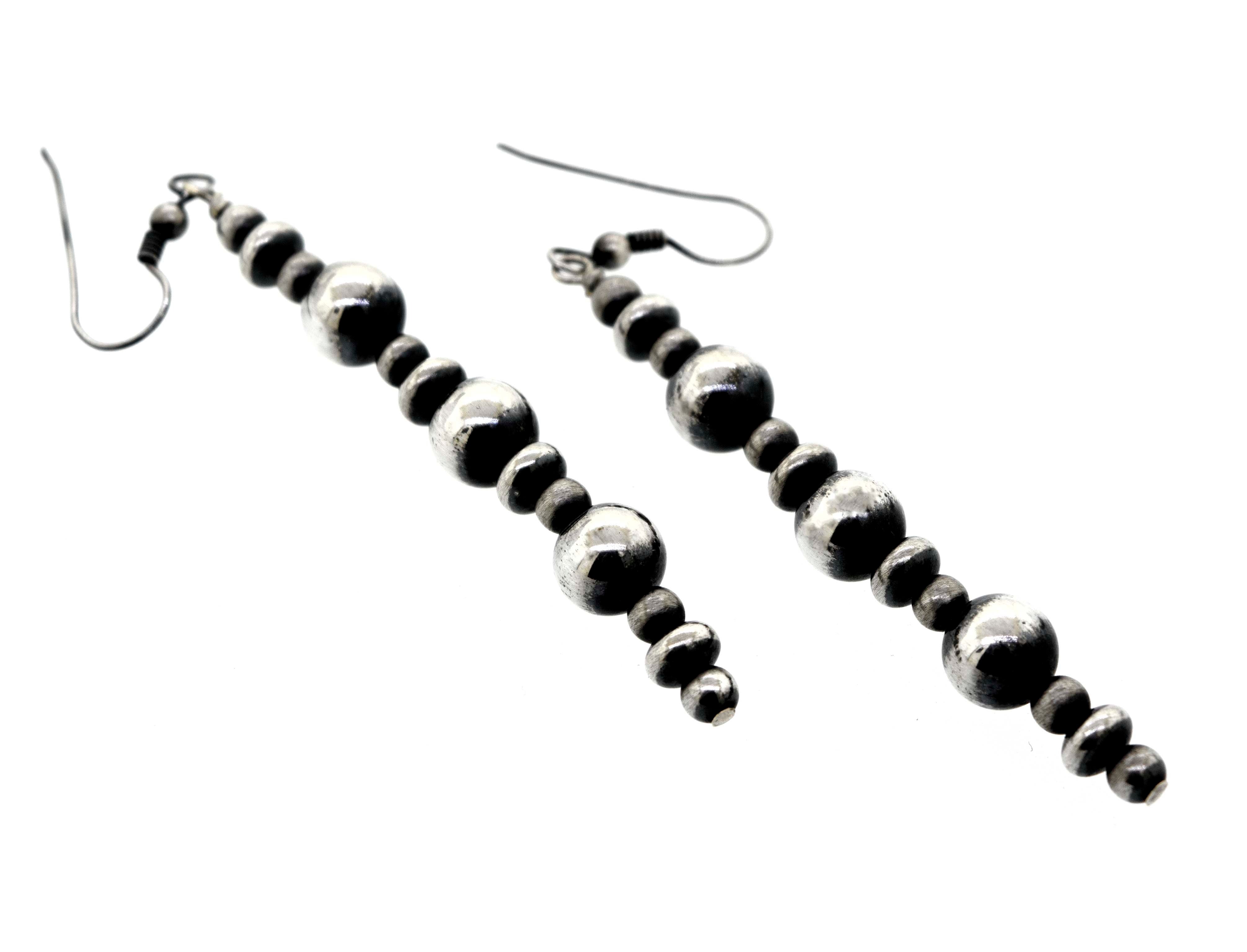 A pair of Long Handcrafted Navajo Pearl Earrings by Super Silver with an oxidized finish, on a white background.