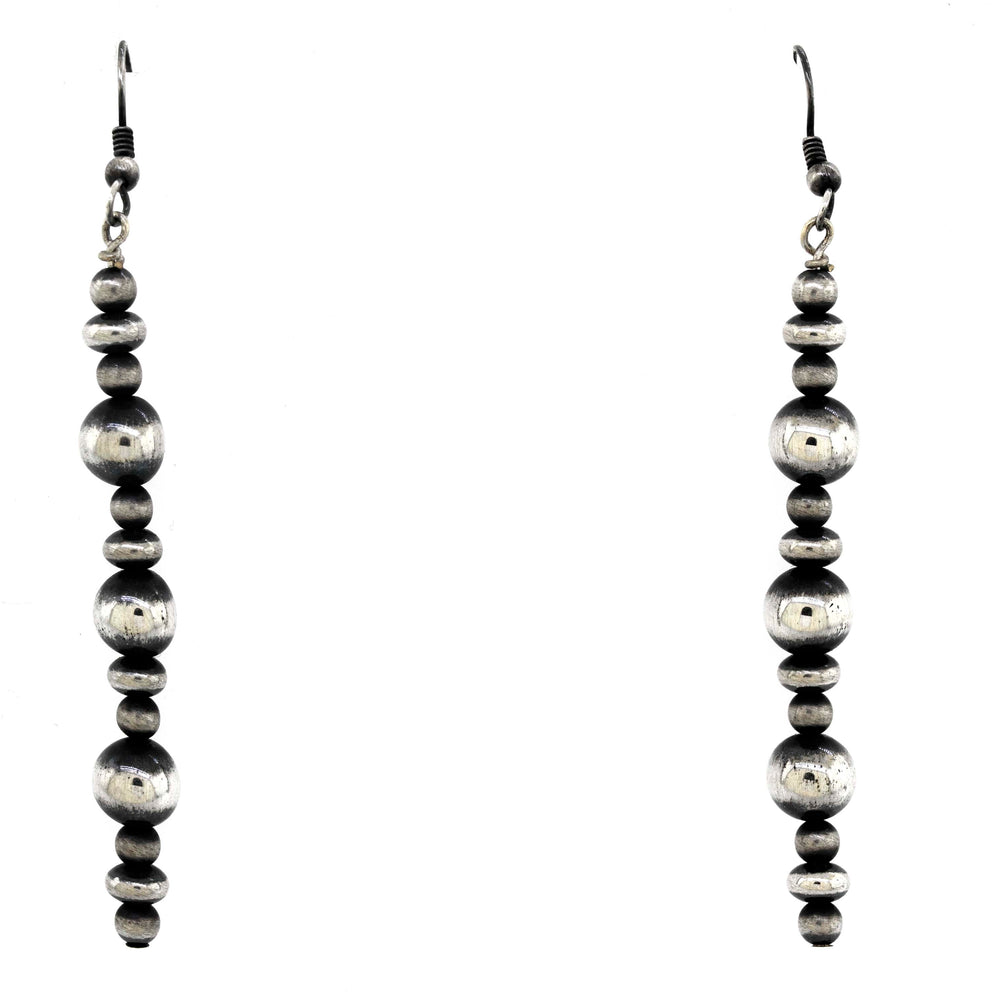 
                  
                    A pair of vintage-styled Super Silver Navajo pearl earrings with an oxidized finish on a white background.
                  
                