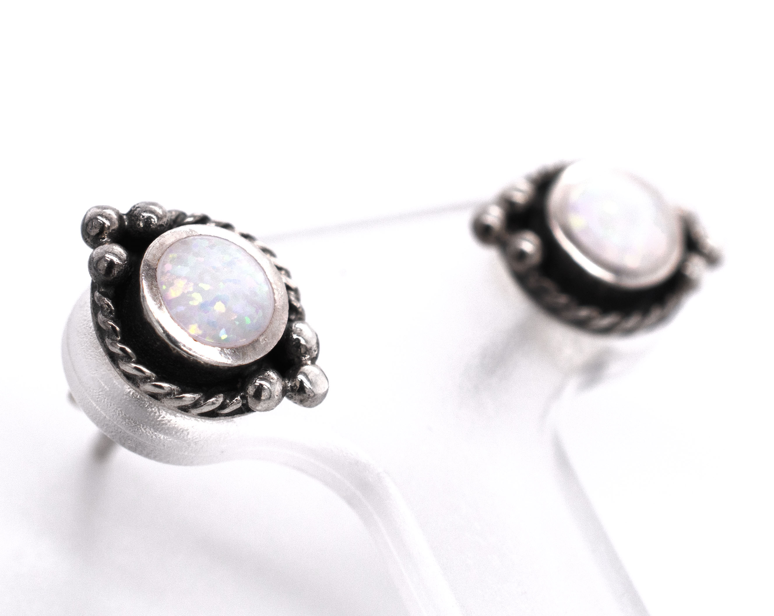 A pair of Super Silver Bali Style Opal Stud Earrings, featuring white opal, on a white background.