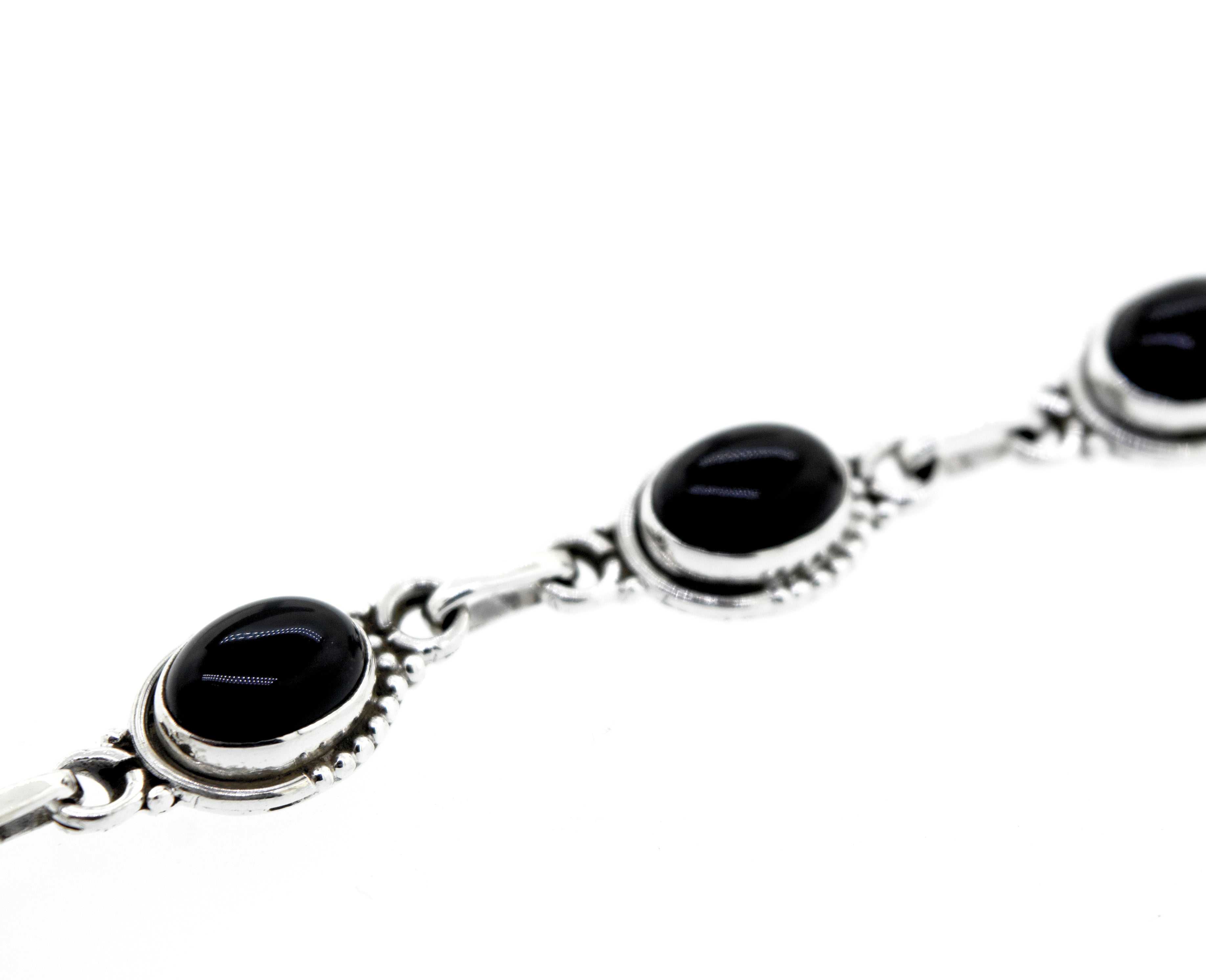 A bohemian chic Oval Gemstone Bracelet With Half Ball Border adorned with black onyx gemstone stones.