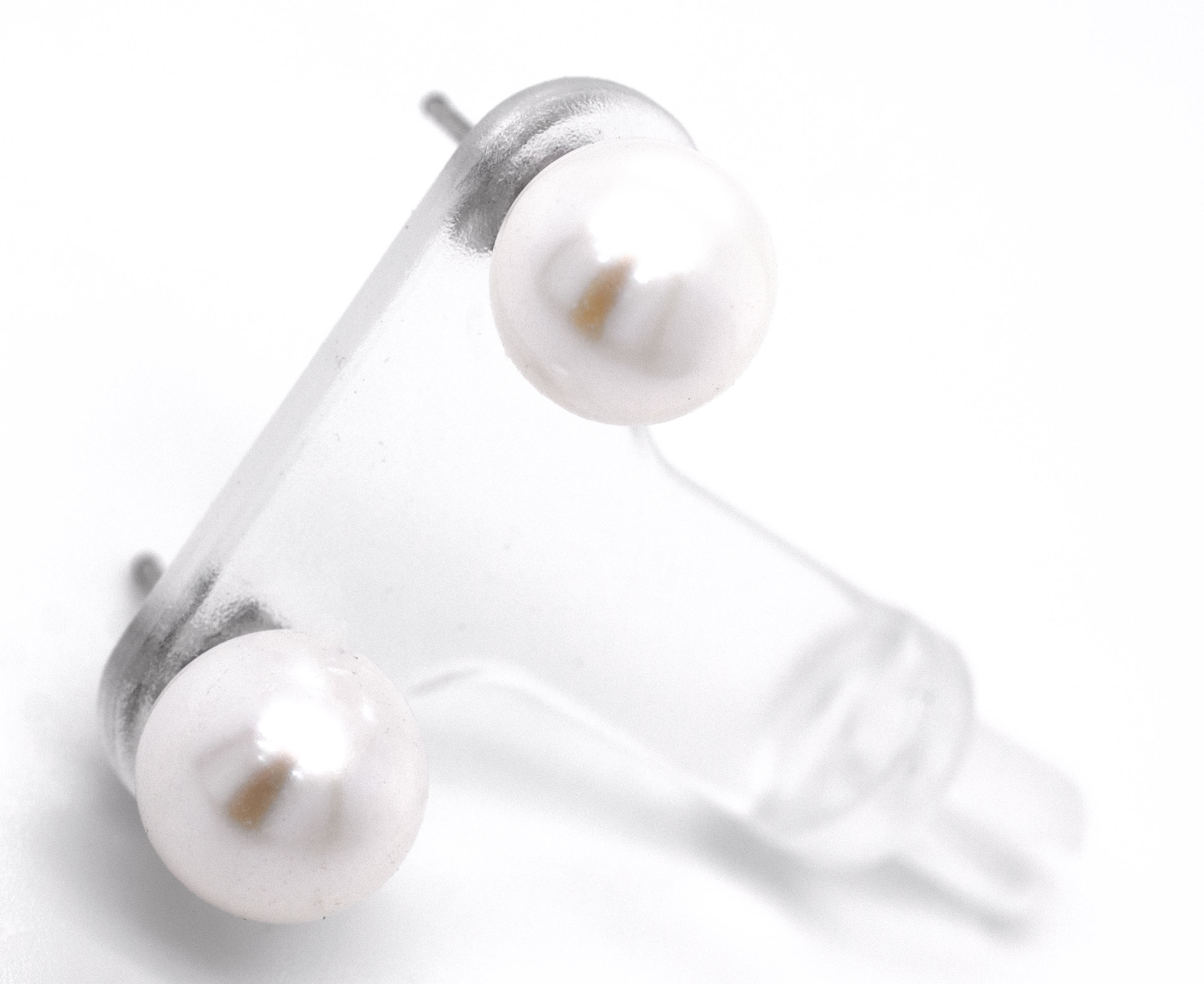 A pair of Super Silver Classic Pearl Stud Earrings on a white surface.