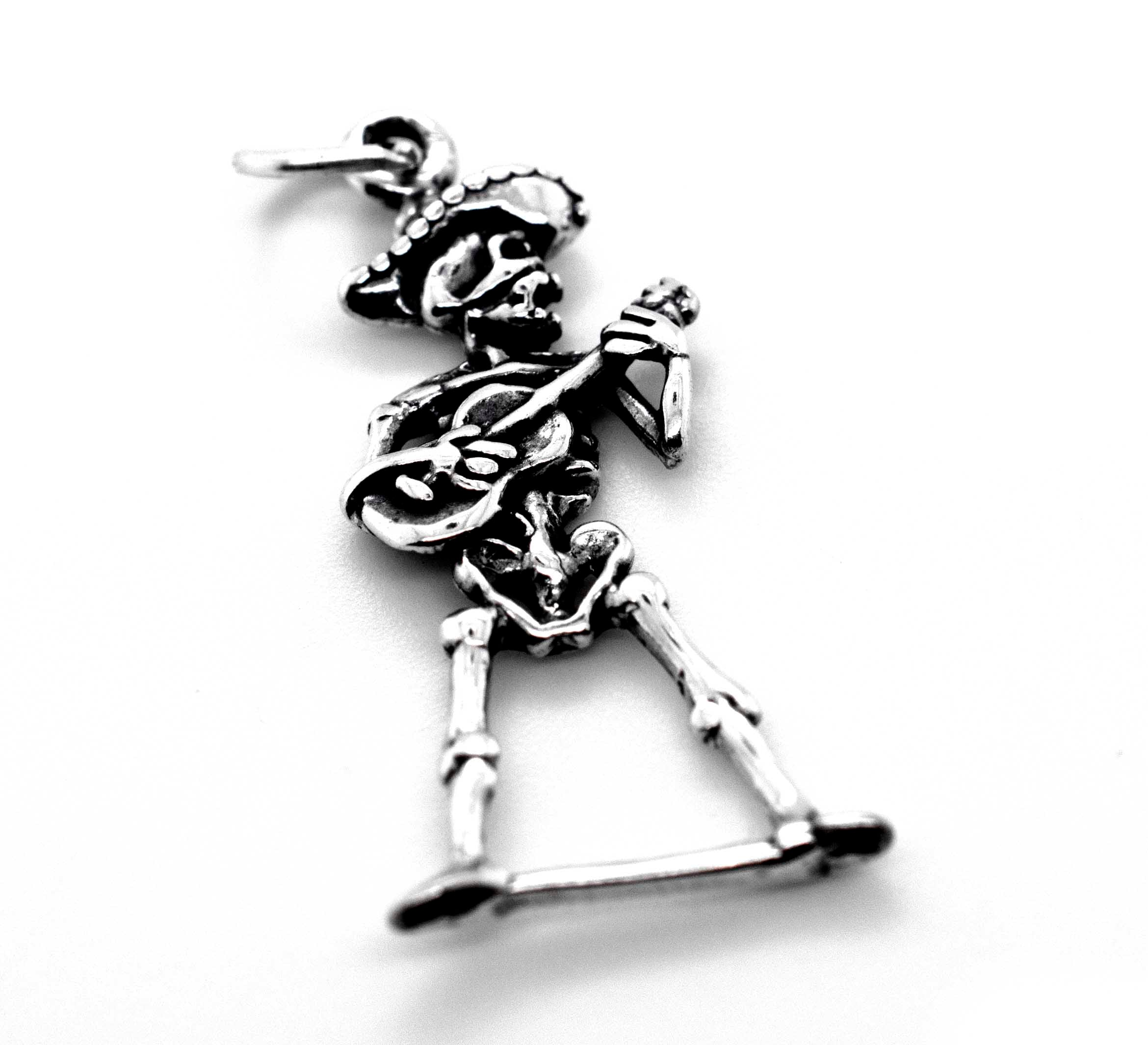 A Super Silver mariachi skeleton with guitar charm on a white background for Día De Los Muertos.