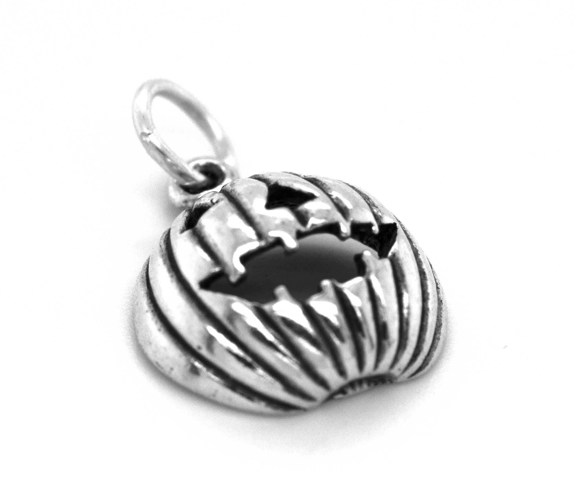 A Grinning Jack O' Lantern Charm by Super Silver on a white surface, perfect for Halloween or autumn festivities.