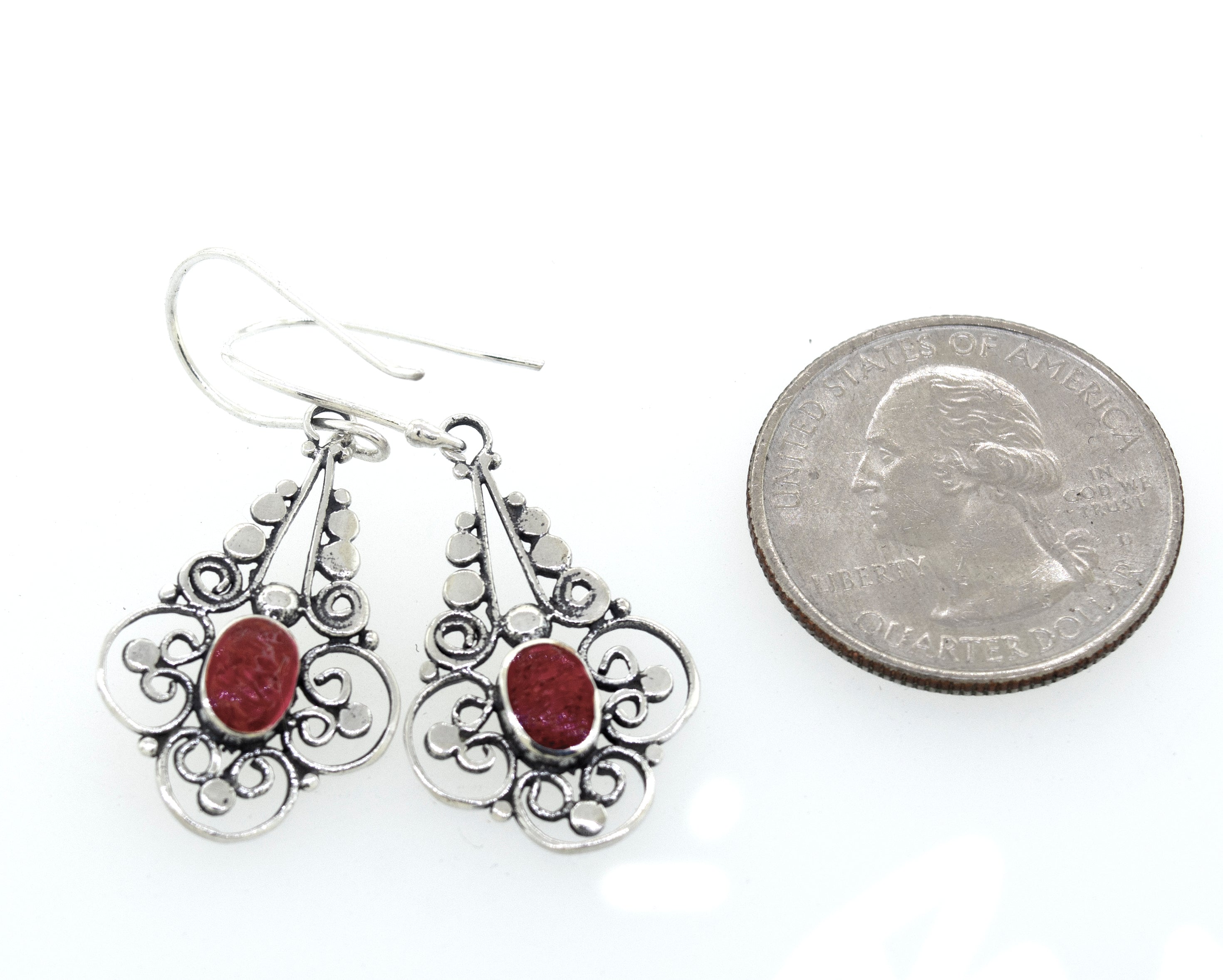 These vibrant Super Silver oval coral dangle earrings with a flower design feature a red stone.