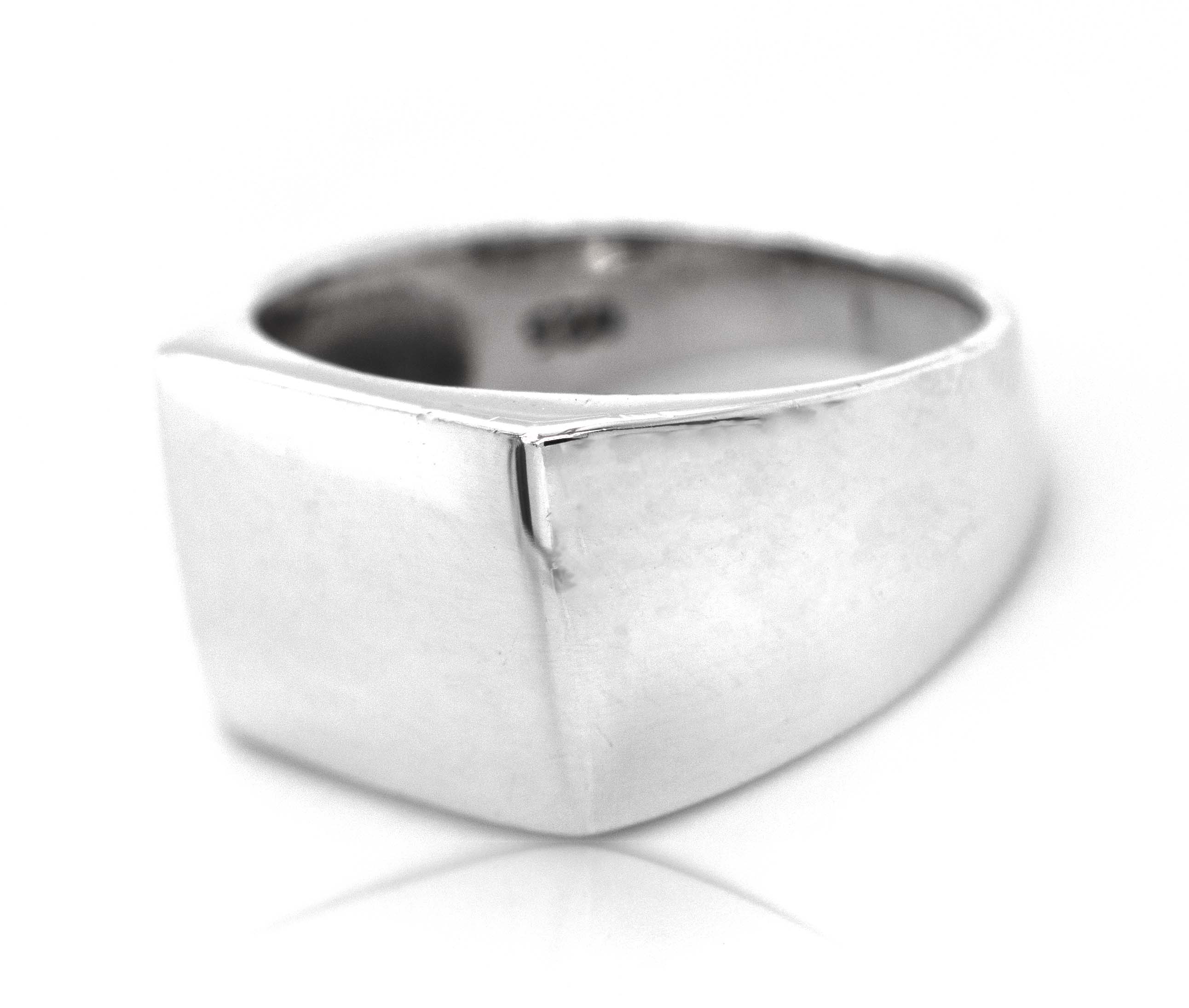 A minimalist silver Signet Ring with a band on a white background.