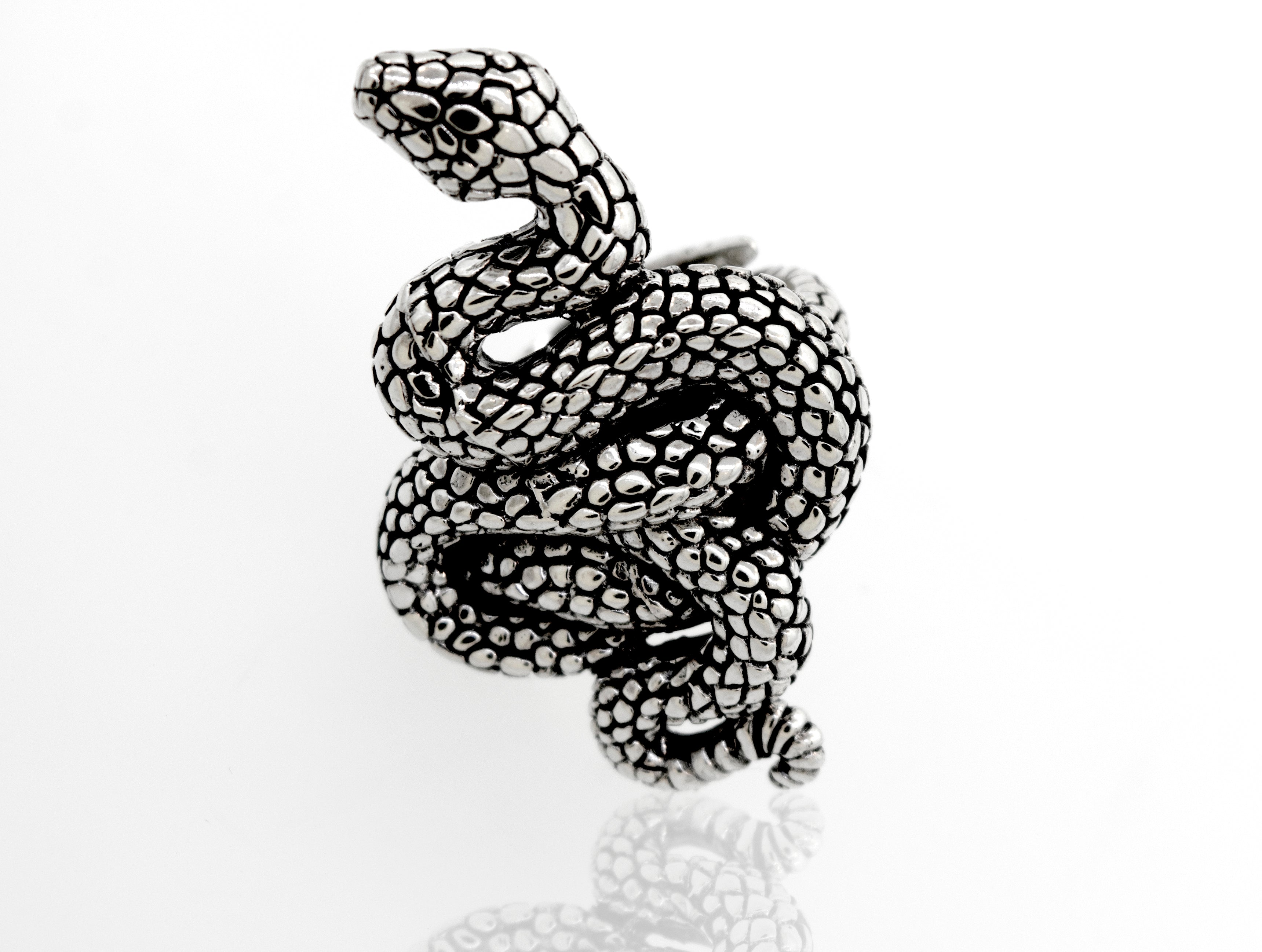 A Coiled Snake Ring by Super Silver, made of .925 Sterling Silver with an adjustable band, resting on a white surface.