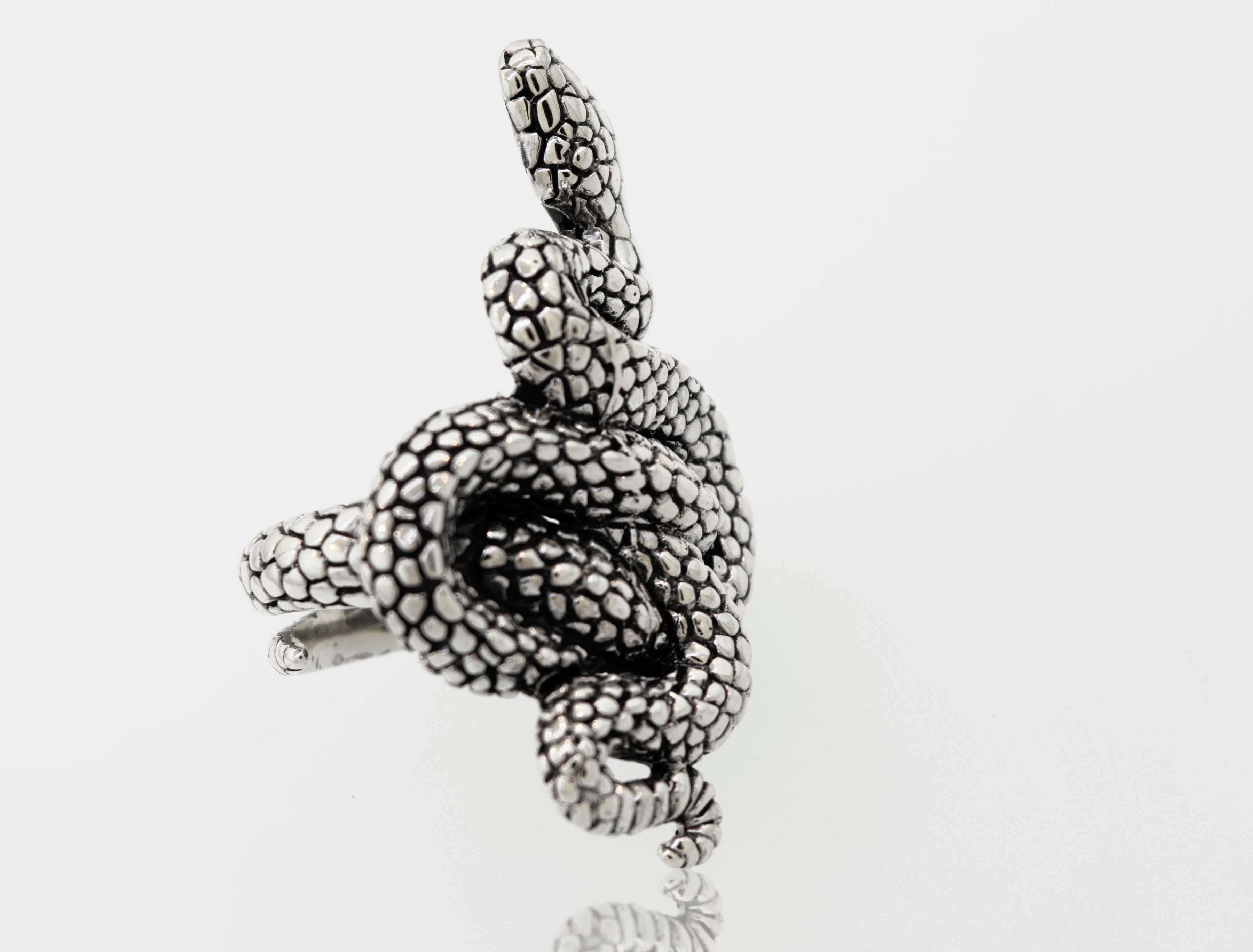 An adjustable band Super Silver Coiled Snake Ring in .925 Sterling Silver, slithering on a white surface.