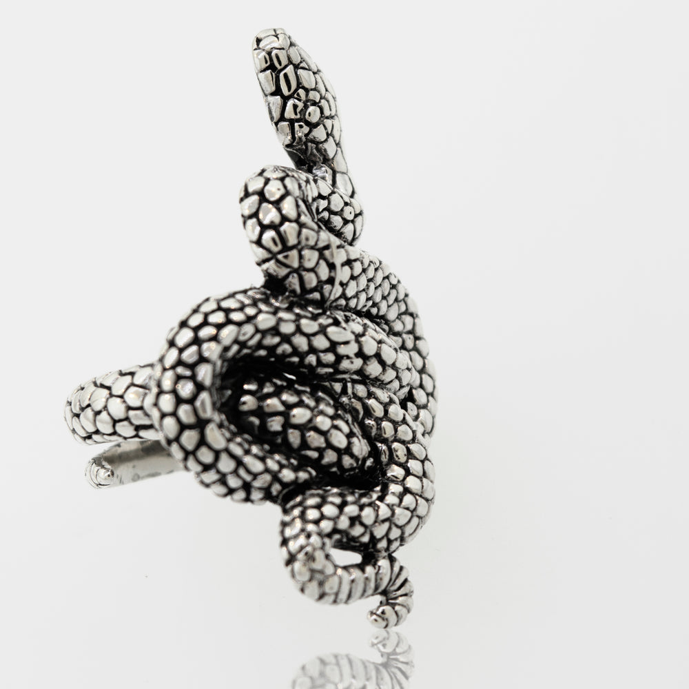
                  
                    A Super Silver Coiled Snake Ring with an adjustable band slithering on a white surface.
                  
                