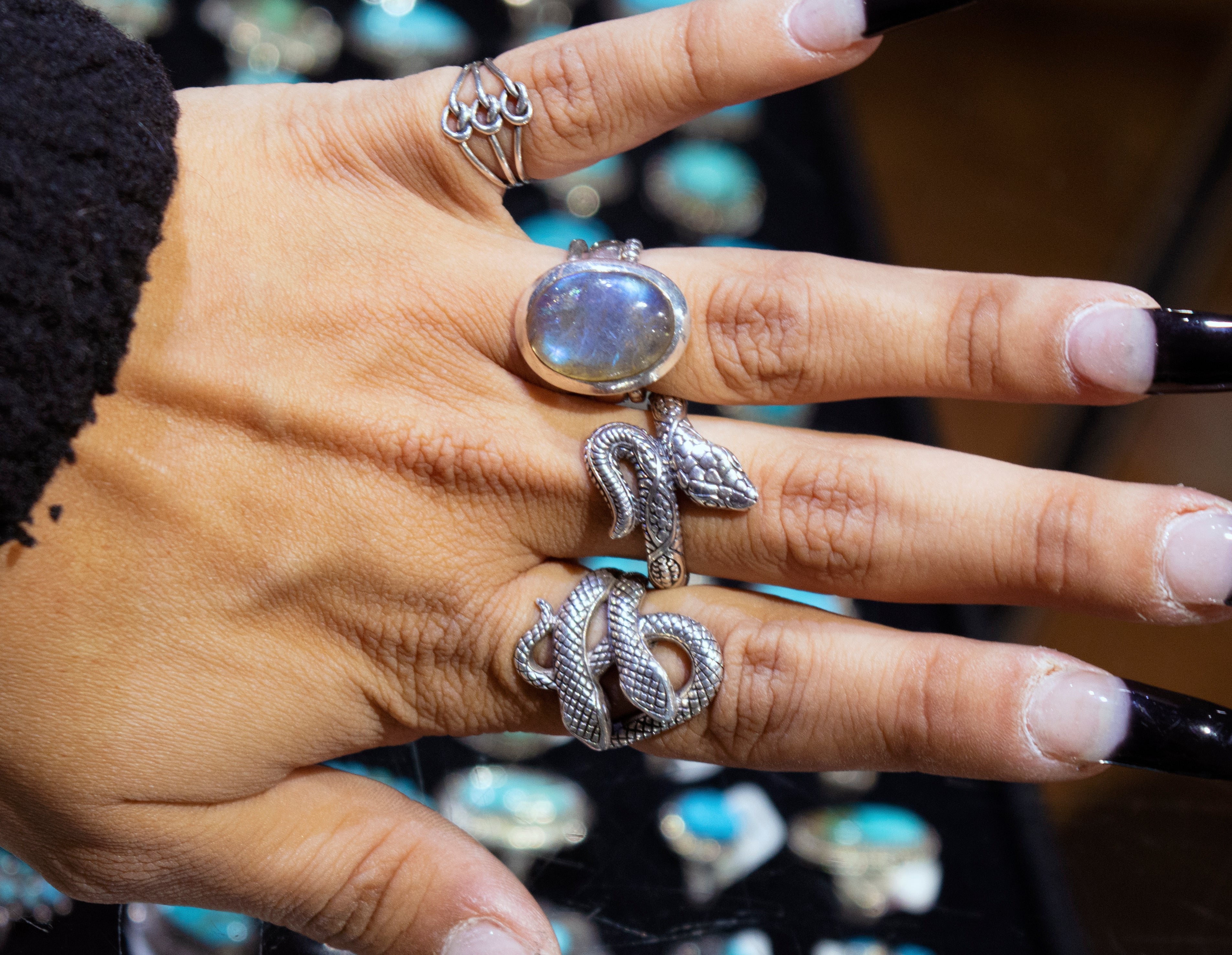 A handcrafted Super Silver Double Headed Snake Ring beautifully adorns a woman's hand.