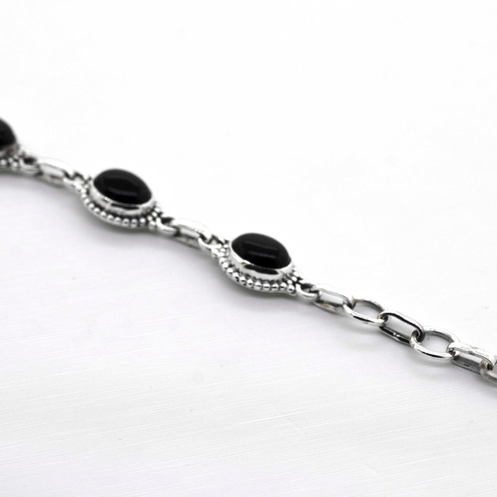 
                  
                    A Super Silver Oval Gemstone Bracelet With Ball Border on a white surface.
                  
                