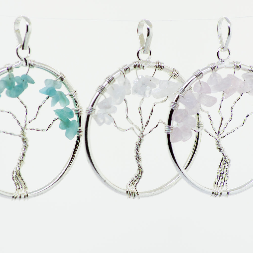 Three Wire Wrapped Tree of Life pendants with Stones hanging from a chain, made by Super Silver.