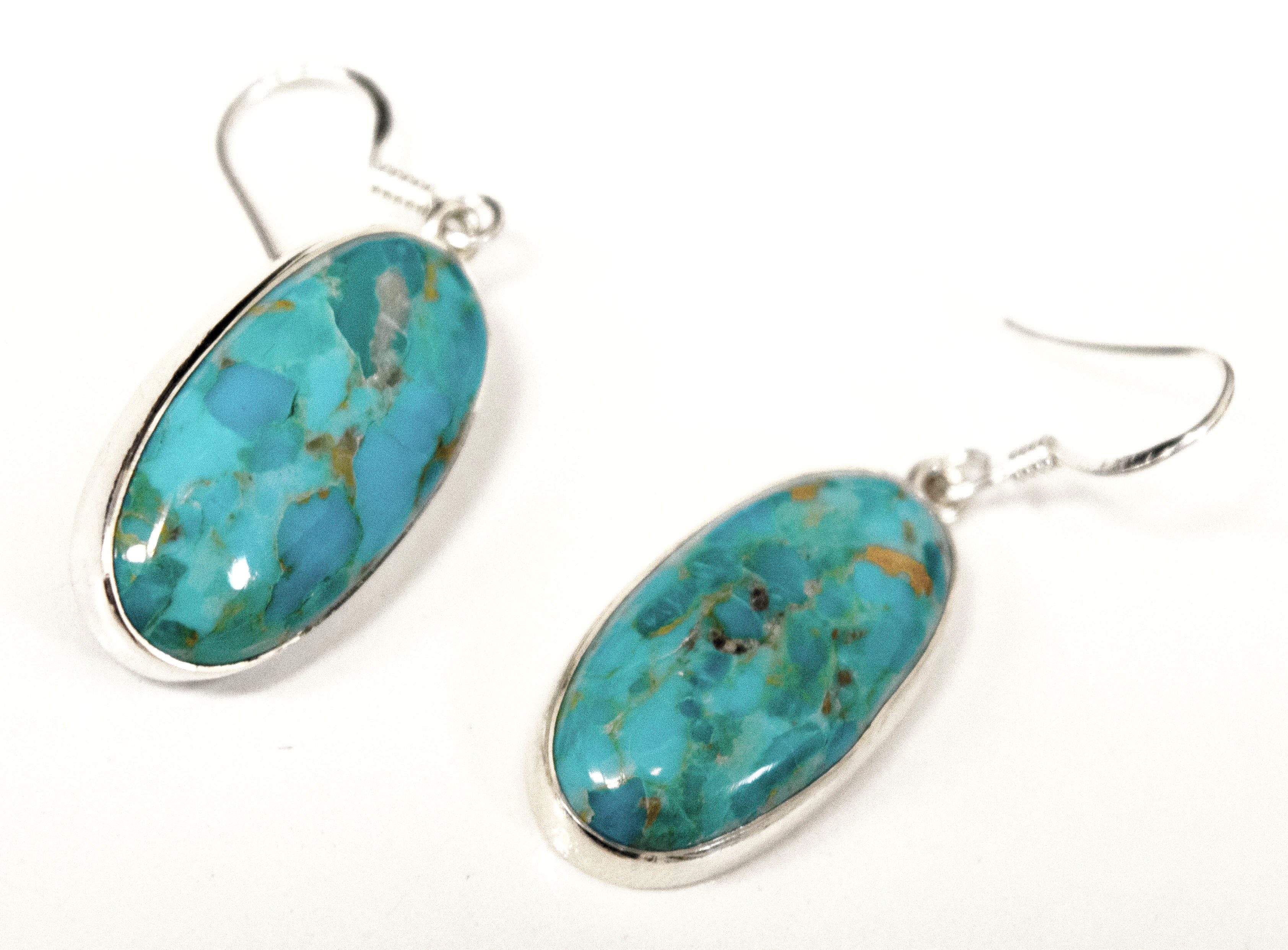 A pair of Super Silver Beautiful Oval Shape Composite Turquoise Earrings on a white background.