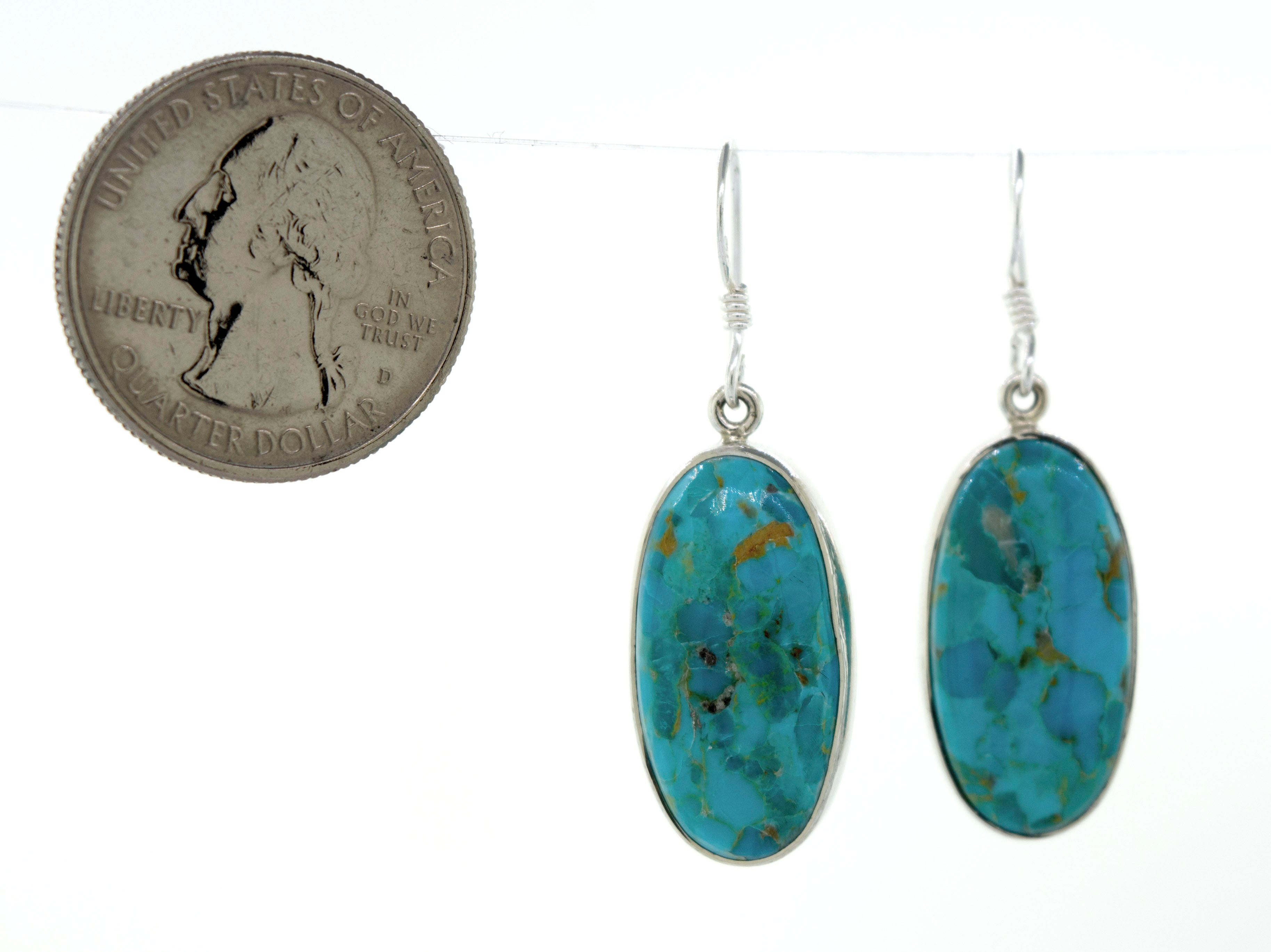These Beautiful Oval Shape Composite Turquoise Earrings by Super Silver feature a dime, adding a touch of uniqueness to your summer outfit. Made with sterling silver for durability and style.
