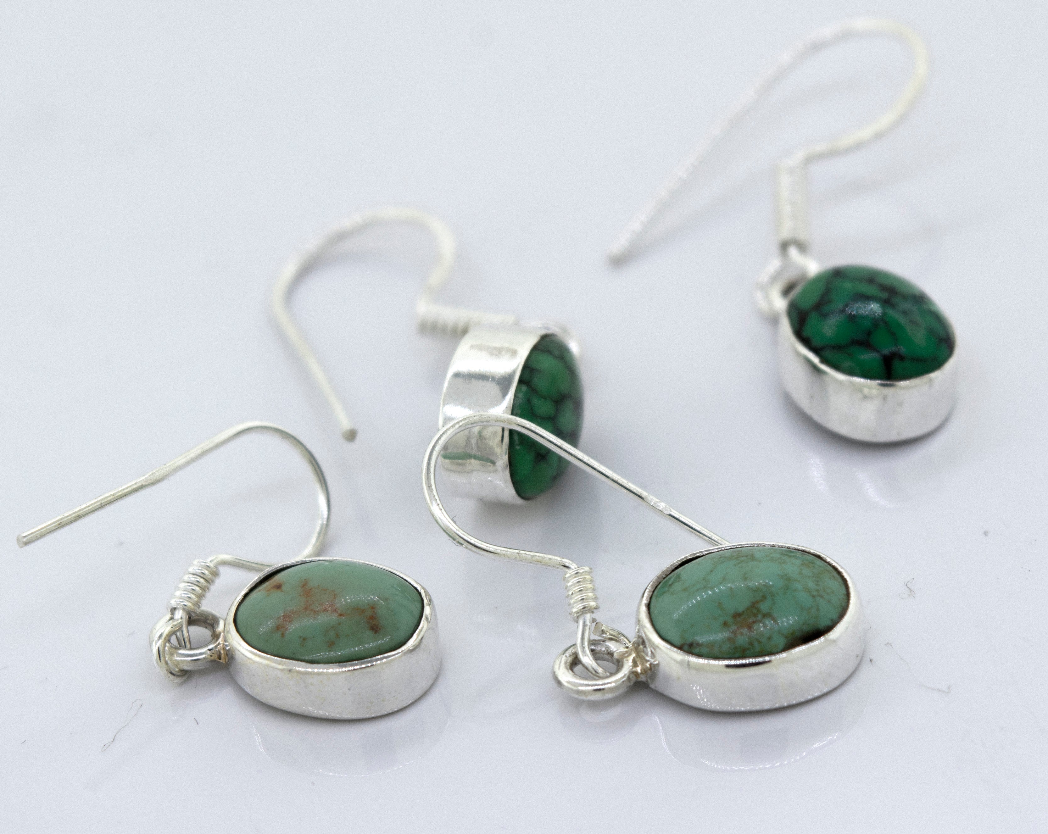 A pair of Super Silver oval natural turquoise dangle earrings, featuring oval-shaped natural turquoise stones, adds a touch of elegance to any outfit.