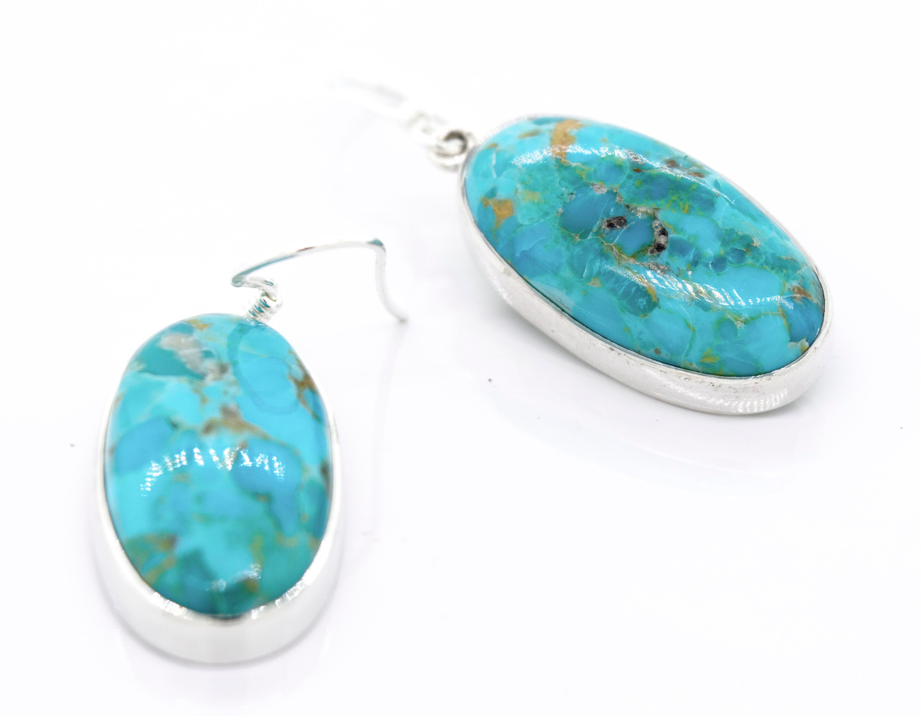 A pair of Super Silver Beautiful Oval Shape Composite Turquoise Earrings on a white surface.
