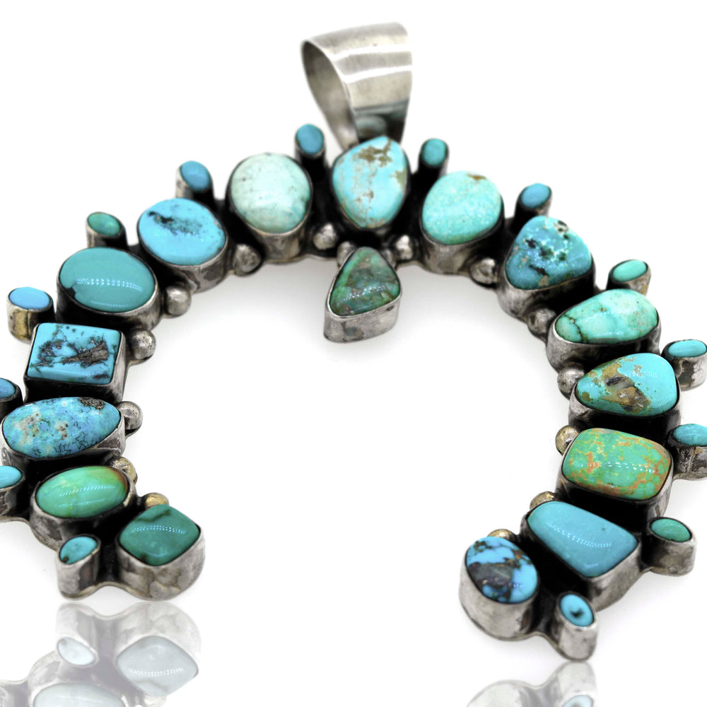 A Super Silver Stunning Handcrafted Naja Pendant with turquoise stones.