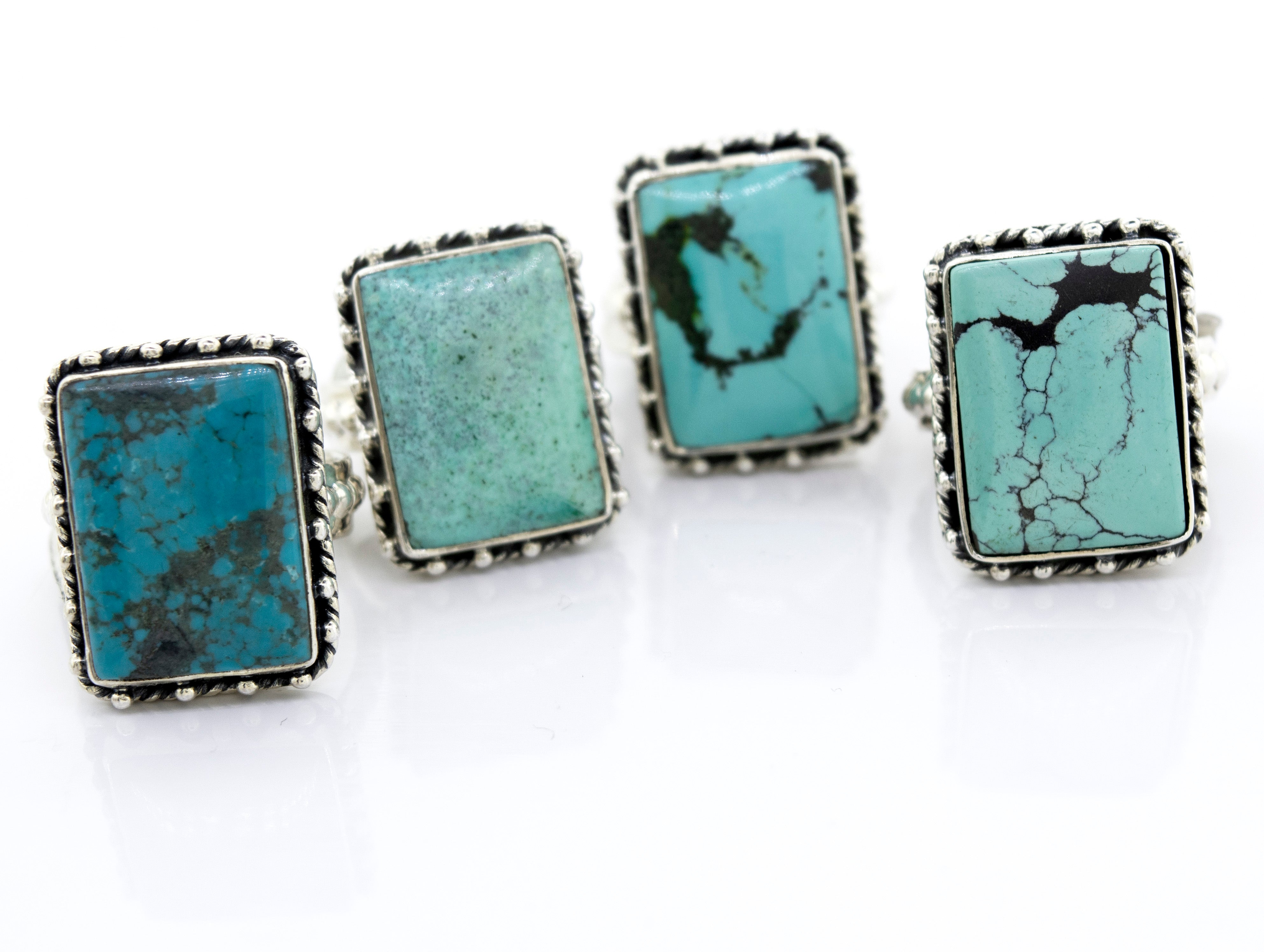 Four Rectangular Shape Natural Turquoise Rings With Ball Border set on a white surface from the Super Silver brand.