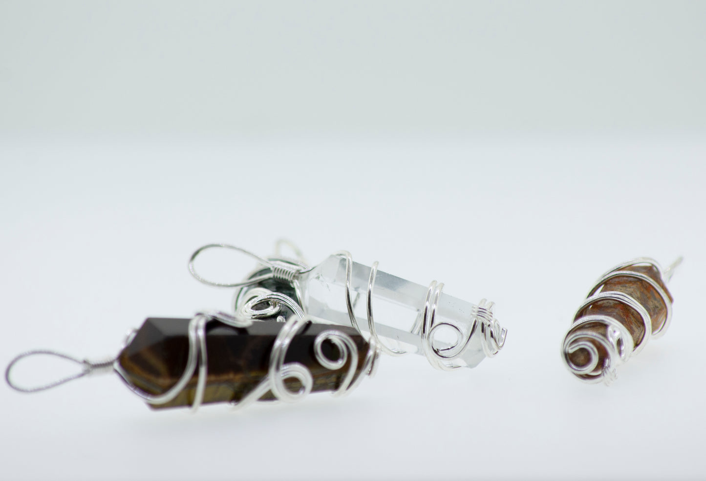 Three Super Silver Wire Wrapped Stone Pendants on a white surface.