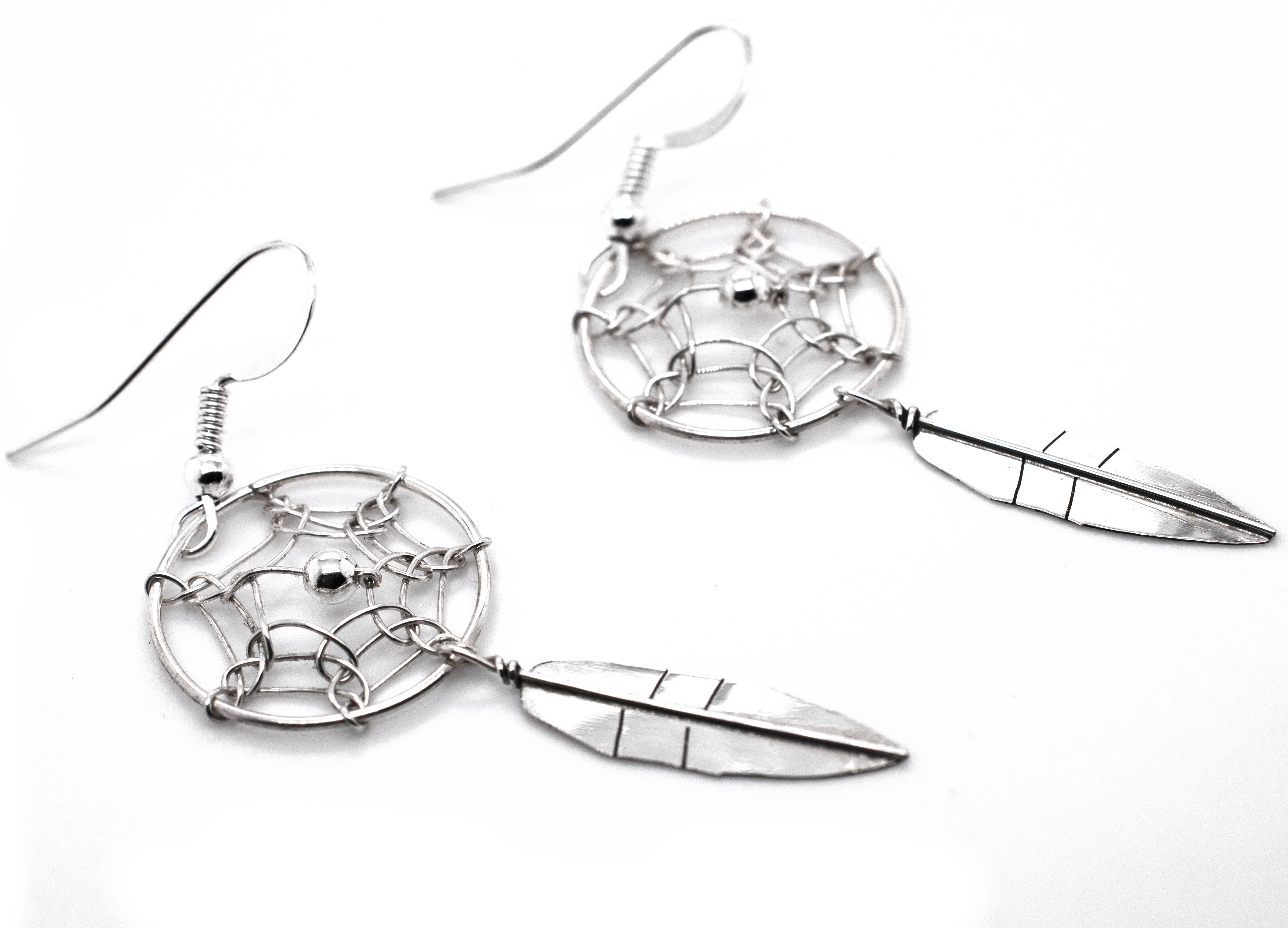 A pair of authentic Super Silver Zuni dreamcatcher earrings with feathers.