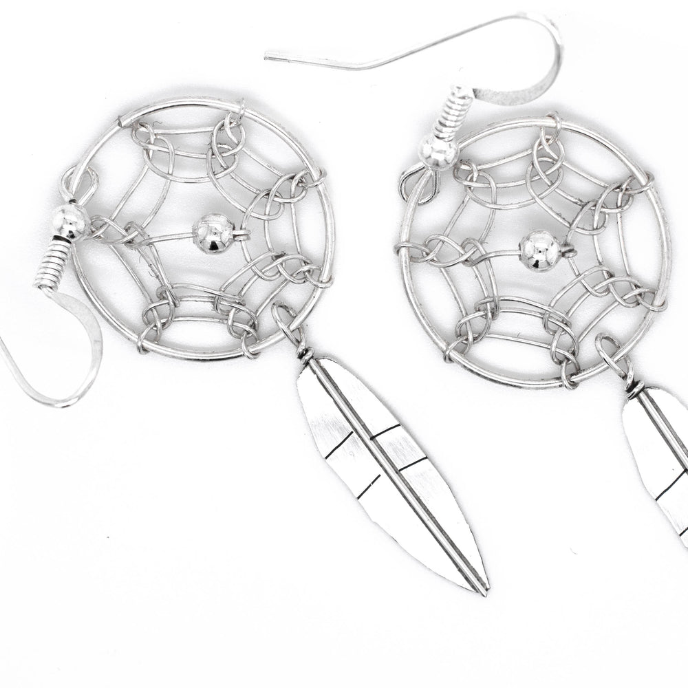 An authentic pair of Super Silver Zuni dreamcatcher earrings on a white background.