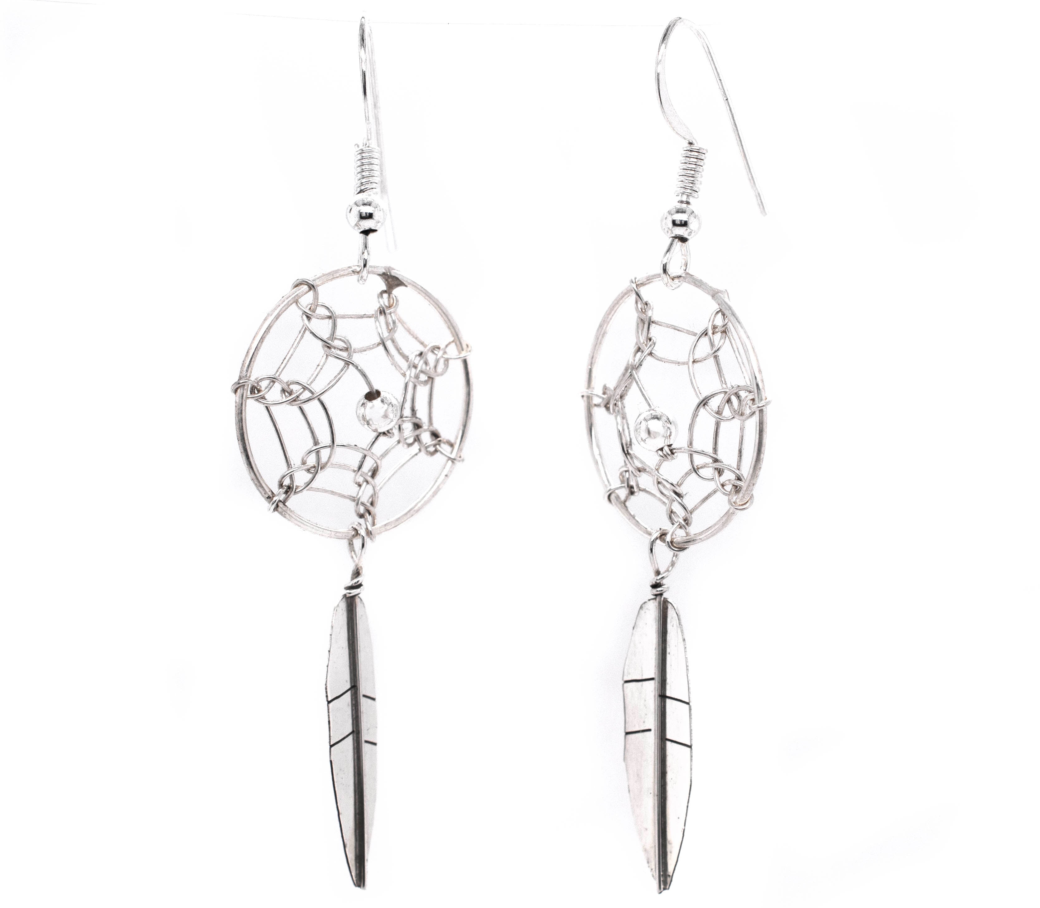 A pair of authentic Super Silver Zuni dreamcatcher earrings on a white background.