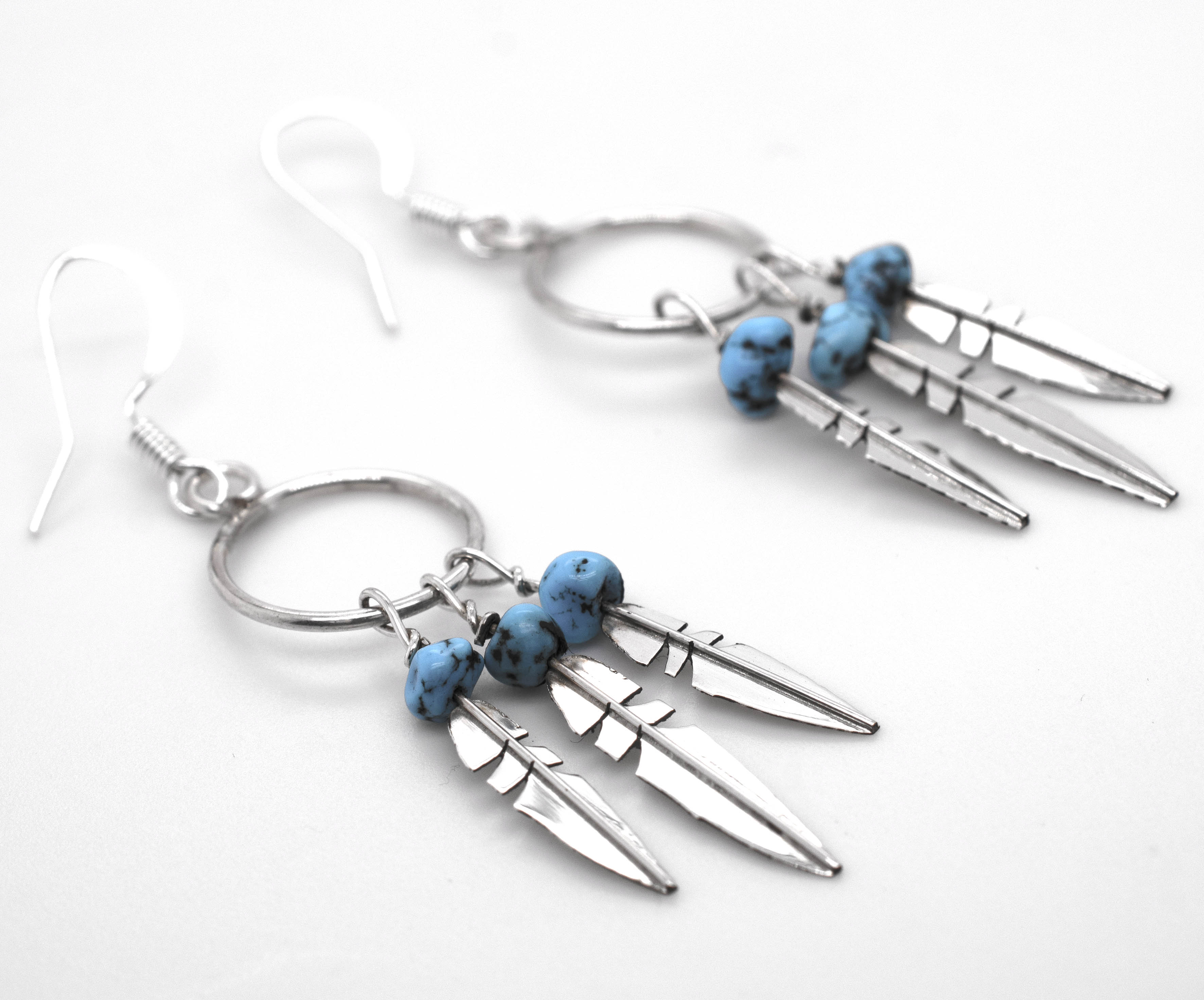 A pair of Enchanting Zuni Feather Earrings with Coral Or Turquoise Beads, inspired by Southwest designs, from the brand Super Silver.