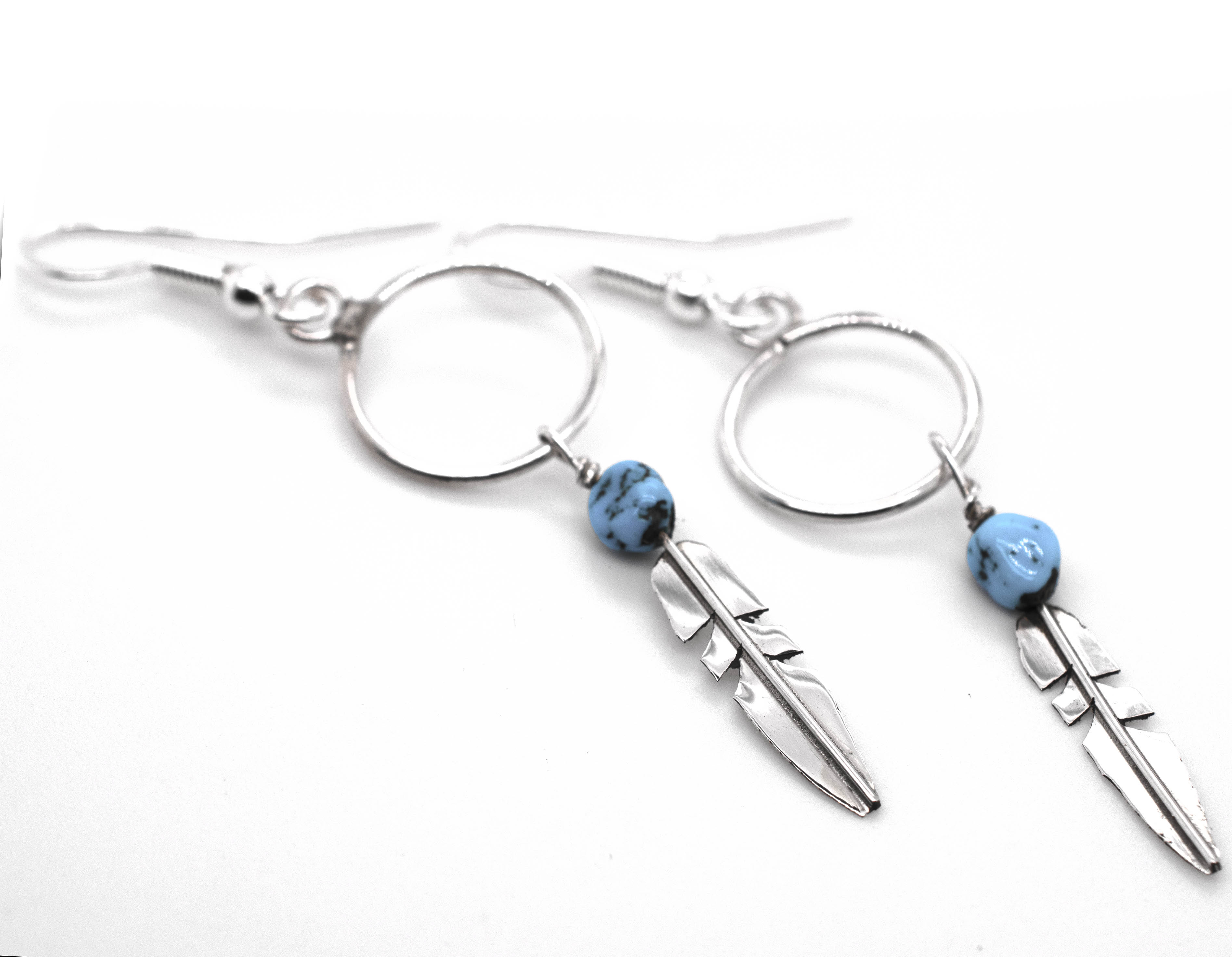 A pair of Super Silver Delicate Zuni Feather Earrings with Coral And Turquoise Beads.