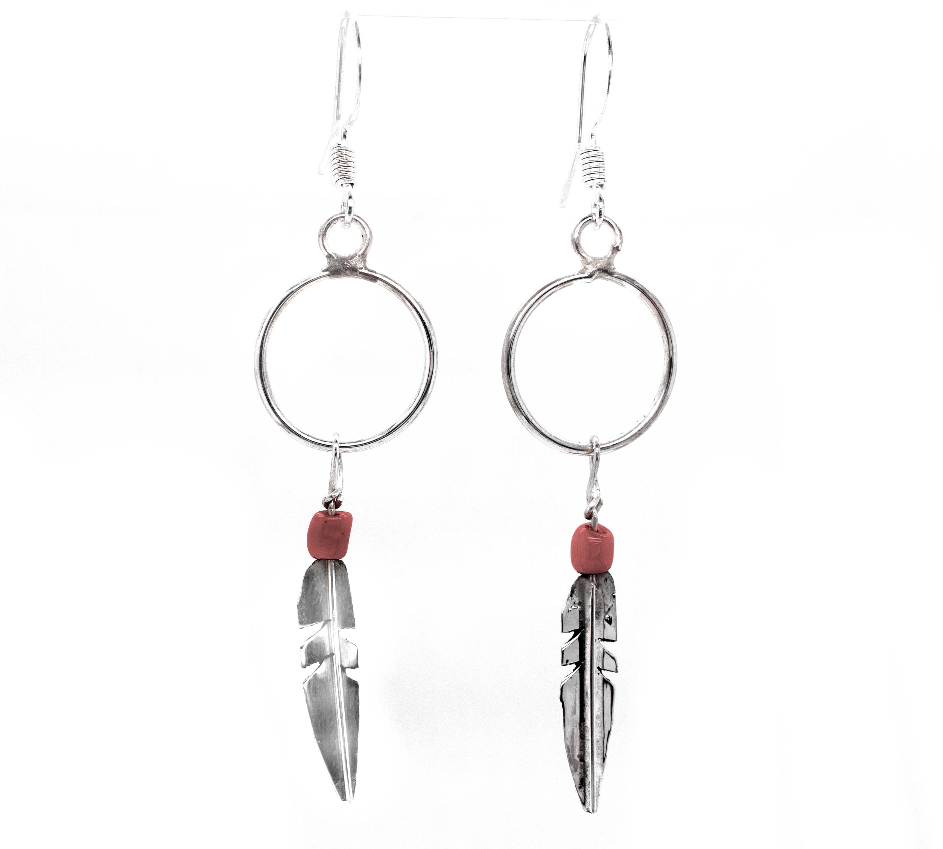 Super Silver's Delicate Zuni Feather Earrings With Coral And Turquoise Beads are southwest-inspired silver dangle earrings adorned with red beads.