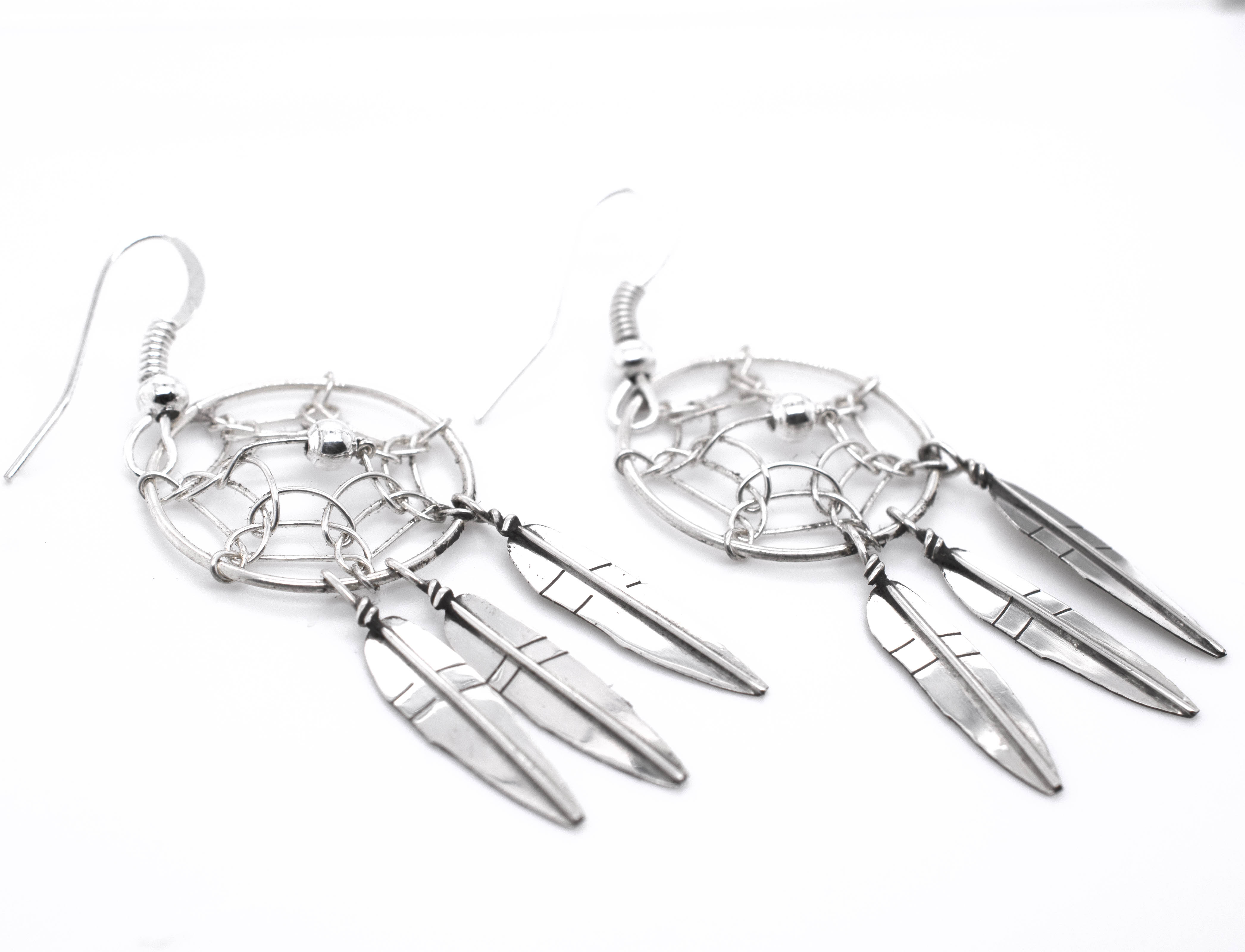 A pair of Stunning Zuni Dreamcatcher Earrings with boho charm on a white background by Super Silver.