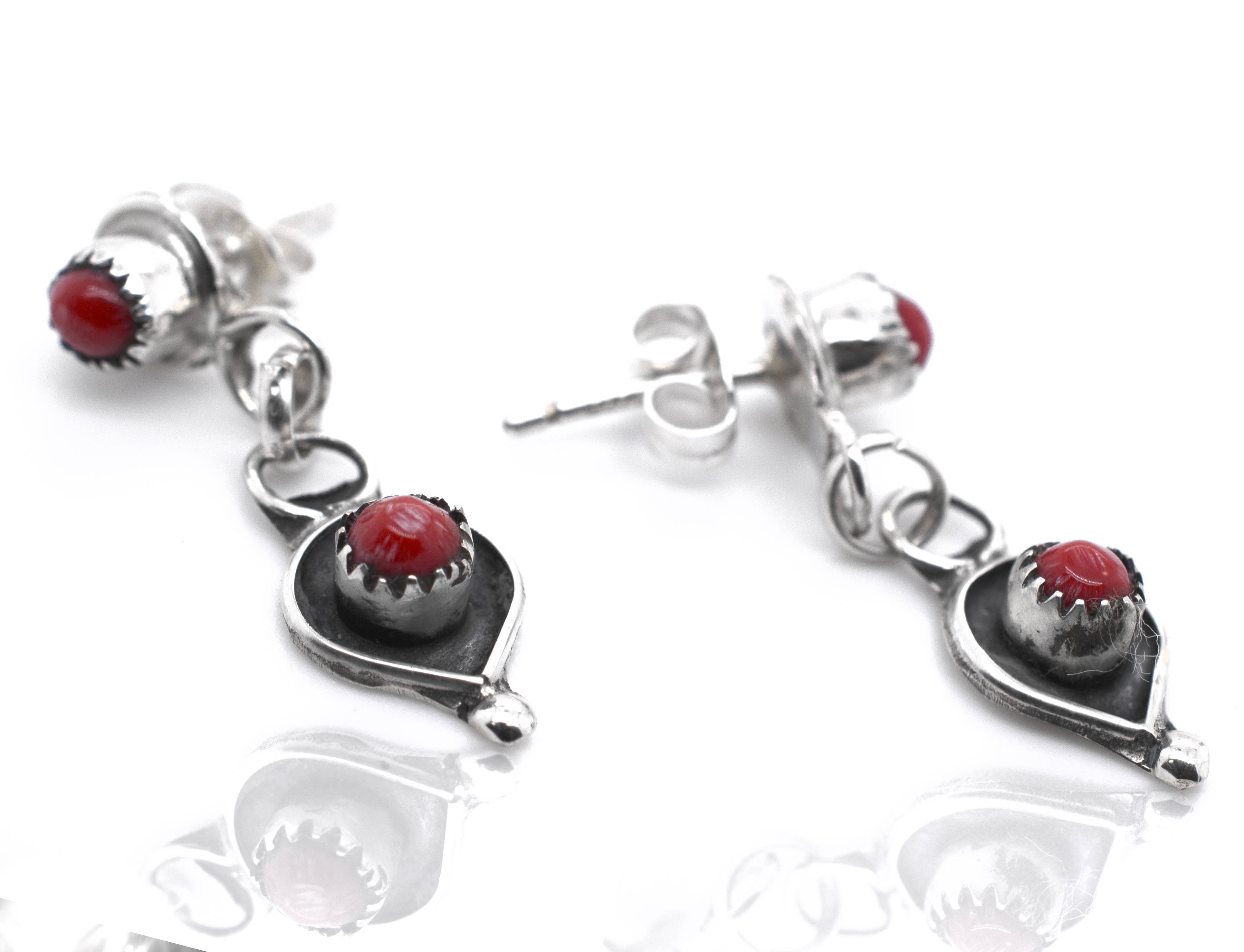 A pair of Super Silver Delicate Zuni Lapis And Coral earrings with red stones.